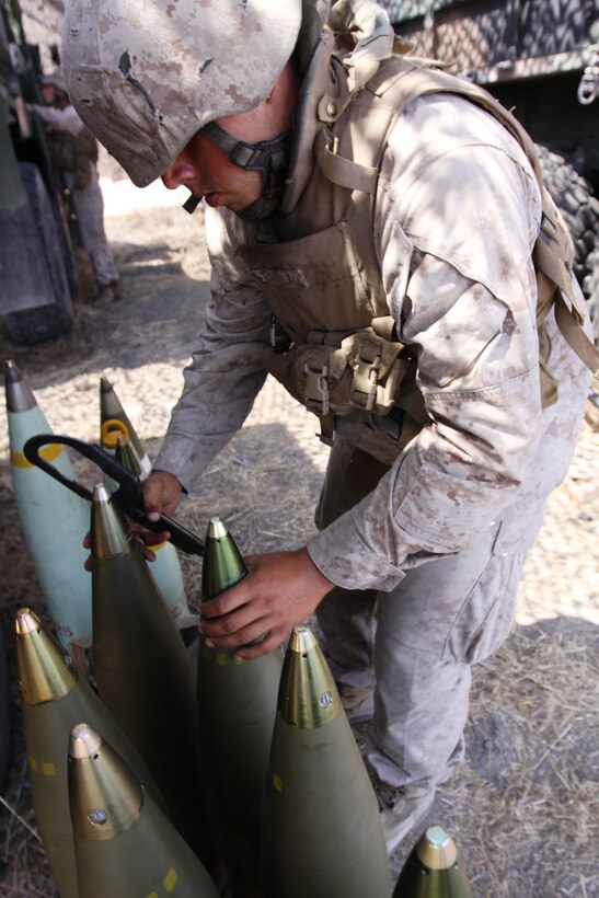 Lance Cpl. Joseph L. Favela, cannoneer, Charlie Battery, 1st Battalion 11th Marine Regiment, prepares several of the 155mm TNT-packed artillery rounds for firing during predeployment training operations on Camp Pendleton, Aug. 17.