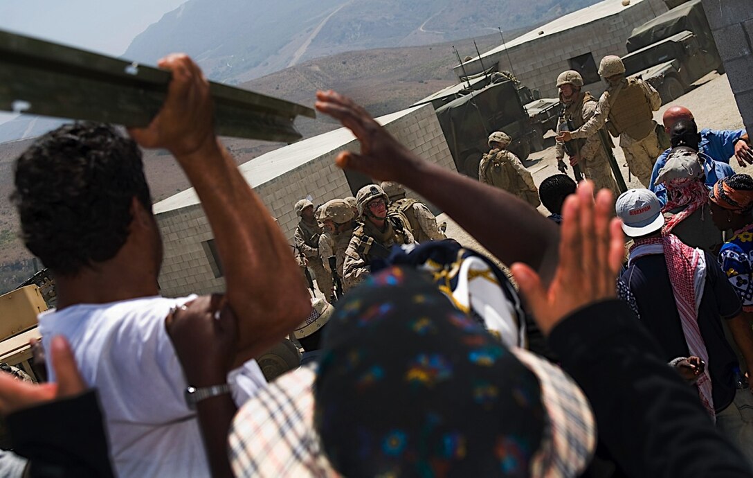 Role players harass 11th Marine Expeditionary Unit Marines as they try to quell a restless crowd of hungry African villagers during a humanitarian assistance operation exercise here Aug. 17. Members of the 11th MEU trained for several missions Aug. 16-17, including humanitarian assistance operations, noncombatant evacuation operations and mass casualty evacuations. The scenarios are part of the MEU’s certification exercise, the MEU’s final training before deploying later this year.