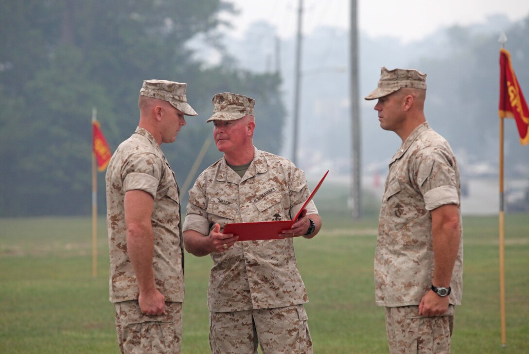 Brig. Gen. W. Lee Miller Jr., the acting commanding general for 2nd Marine Division, presents the Bronze Star award citation to Gunnery Sgt. Chad L. Miller, the radio chief for 5th Battalion, 10th Marine Regiment, 2nd Marine Division, aboard Marine Corps Base Camp Lejeune, N.C., June 29, 2011. Miller was awarded the Bronze Star with combat distinguishing device for heroic actions in Kunar Province, Afghanistan in 2009.
