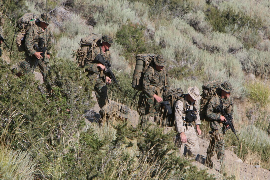 Staff Sgt. Michael P. Hutton, an instructor with the Unit Training Group, leads a company of Marines down a hillside after a conditioning hike here Aug. 18. The instructors participate in nearly all the training visiting units do, keeping them in good physical condition.