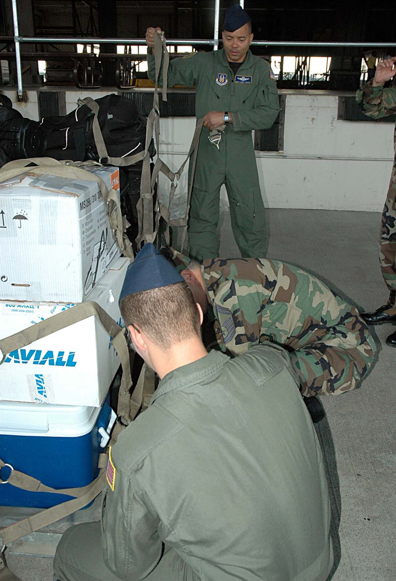 Master Sgt. Leon Harper (top) a Reservist with the 728th Airlift Squadron at McChord Air Force Base, Wash., assists with a pallet of luggage for the Team McChord crew heading out to perform Winter Fly-ins in support of Operation Deep Freeze.  (U.S. Air Force photo/Senior Airman Patrick Cabellon)