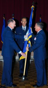 Gen. C. Robert Kehler, commander Air Force Space Command, passes the official flag to Maj. Gen. Richard E. Webber, making him the first commander of the 24 AF.  Chief Master Sgt. Todd Small, AFSPC command chief, looks on.  The 24th Air Force activation under Air Force Space Command is a major milestone in the combination of space and cyberspace operations within one command. General Kehler presided over the ceremony to activate the new numbered Air Force. (Courtesy photo)