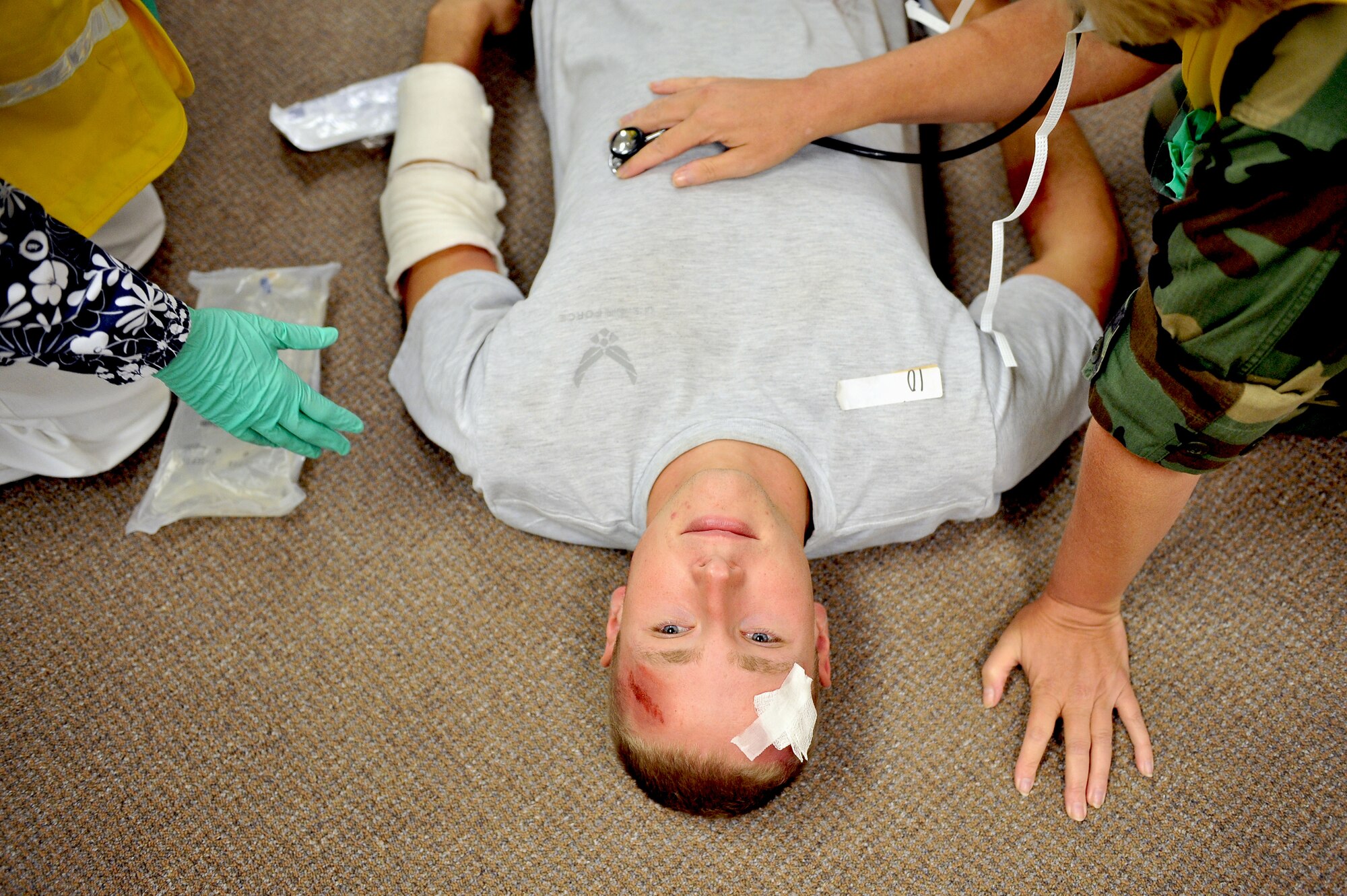 SHAW AIR FORCE BASE, S.C. -- Airman 1st Class Phillip Collar, a simulated casualty, is treated for his wounds during a major accident response exercise, Aug. 14. Testing the ability of an installation's emergency responders and medical teams to handle crisis situations, a MARE input can be anything from a hazardous material aircraft crash to a biochemical terrorist attack. (U.S. Air Force photo/Senior Airman Kathrine McDowell)
