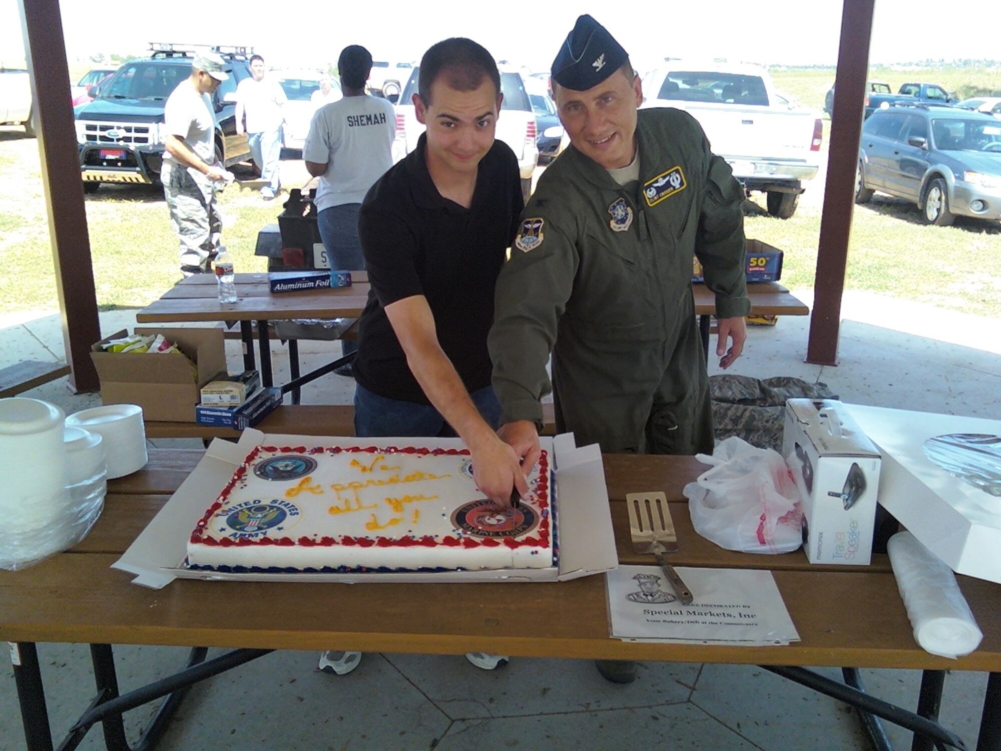 BUCKLEY AIR FORCE BASE, Colo. -- Col. Clint Crosier (right), 460th Space Wing commander, and Airman Matthew Mendez, 460th Space Communications Squadron, cut the cake at Junior Enlisted Appreciation Day picnic at Lake Williams Aug. 7. Team Buckley's 5/6 Association put on the event for the E-1 through E-4 Airmen, Soldiers, Sailors and Marines on Buckley, (U.S. Air Force photo)