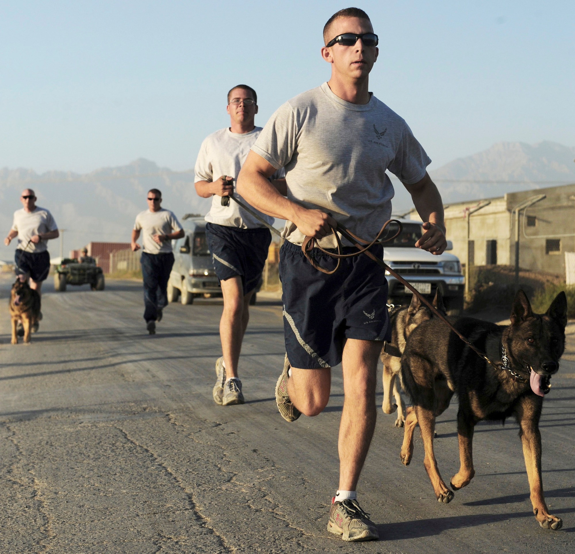Staff Sgt. Chris Reynolds (from left to right), Tech. Sgt. Drew Odell, Staff Sgt. Justin Kitts and Staff Sgt. Scott Carpenter go on a training run Aug. 9 at Bagram Airfield, Afghanistan. The dog handlers are deployed to the 455th Expeditionary Security Forces Squadron. K-9 units patrol the base and inspect mail, luggage and vehicles. (U.S. Air Force photo/Staff Sgt. J.G. Buzanowski)