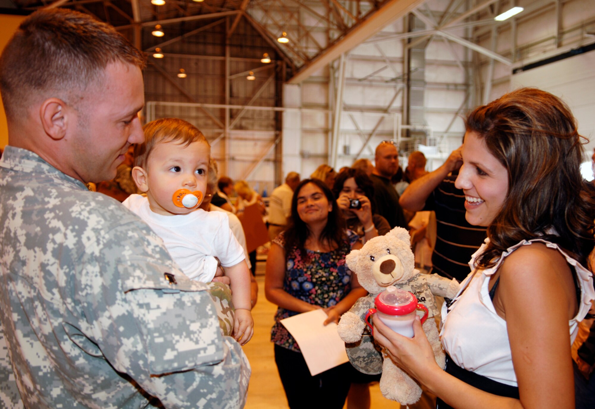 FAIRCHILD AIR FORCE BASE, Wash.–A soldier holds his newborn while his wife looks on after redeployment from a year-long tour in Iraq Aug. 1. A total of 57 Soldiers returned while the remaining will continue to arrive over the next two weeks.  (U.S. Air Force photo / Staff Sgt. Chad Watkins) 