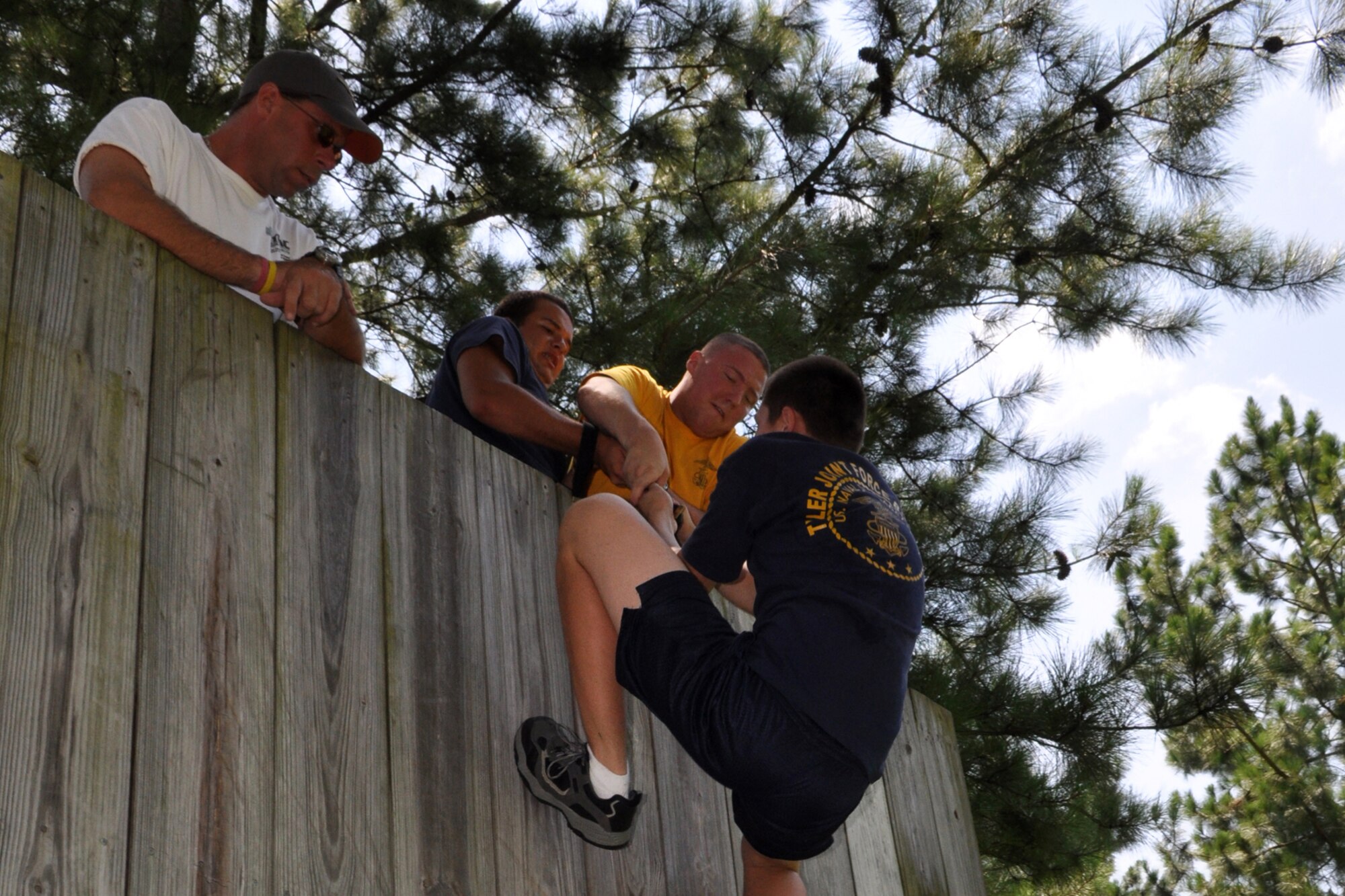 James Whitaker, activities therapy coordinator, East Texas Medical Center/Behavioral Health Center observes members of the TYLER JOINT FORCE Battalion of the U.S. Naval Sea Cadets Corps based in Tyler, Texas, complete an exercise which pit them against a 14-foot wall at the East Texas Medical Center’s Behavioral Health Center in Tyler, August 15, 2009. The exercise was used to help the cadets and officers realize the benefits of depending on a support system to accomplish goals. Participants at the wall learned quickly that without a support system they were unable to do a thing. The cadets and officers spent the entire summer day completing exercises which will enable them to work closer with and trust each other. This experience will also benefit those cadets who decide to join the U.S. Military in the future. (L to R) James Whitaker, Seaman Apprentice Clayton Sims, Ensign Kyle Stowers, operations officer and Seaman Apprentice Seth Loftin. (Courtesy photo) 