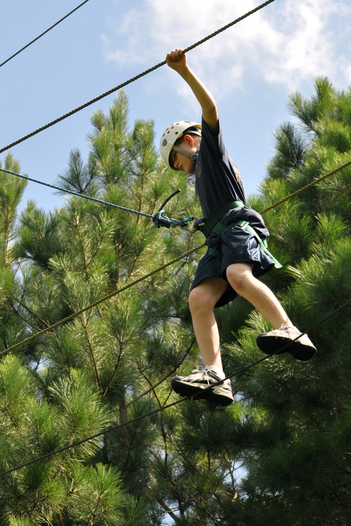 Navy League Cadet Corps Recruit Christopher Leahy traverses a rope bridge more than 20 feet in the air to complete an exercise at the East Texas Medical Center/Behavioral Health Center in Tyler, Texas, August 15, 2009. He is a member of the TYLER JOINT FORCE Battalion of the U.S. Naval Sea Cadets Corps based in Tyler, Texas. A number of NSCC/NLCC cadets spent the entire day completing exercises which will enable them to build trust in their fellow cadets for the future. Recruit Leahy was born in Lincoln, Nebraska, and now calls Texas home. The NLCC is for boys and girls, at least 11 but not yet 14 years old who are interested in the sea and ships, and the nation’s seagoing services. The Navy League program is designed to introduce young people to maritime and military life, and to prepare them for later entrance into the Naval Sea cadet Corps. (Courtesy photo)  