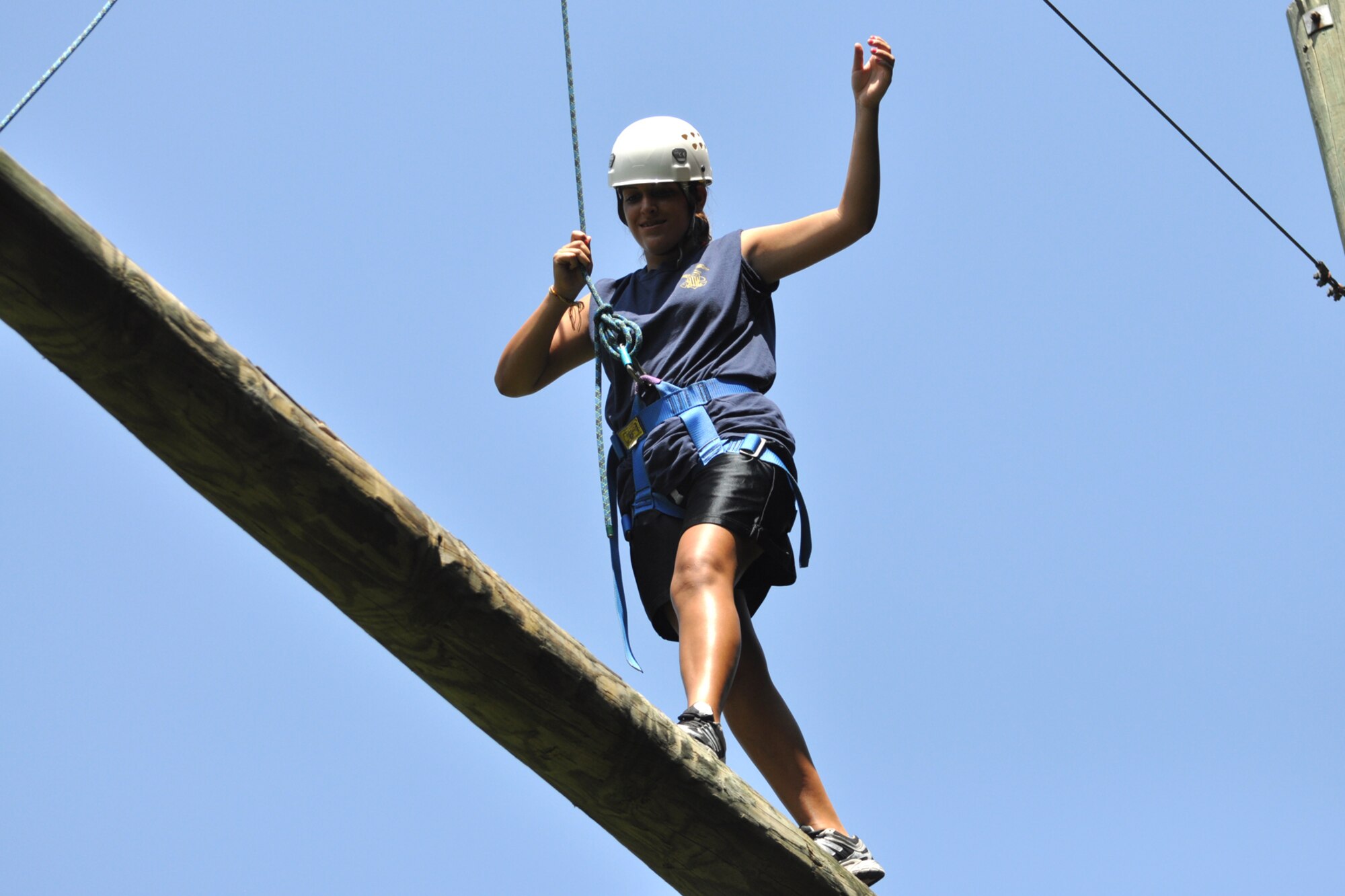 Recruit Brittany Brannon walks across a pole hanging some twenty feet in the air as her fellow cadets urge her on to success at the East Texas Medical Center/Behavioral Health Center in Tyler, Texas, August 15, 2009. Recruit Brannon is a member of the TYLER JOINT FORCE Battalion of the U.S. Naval Sea Cadets Corps based in Tyler. The exercise helps participants overcome their fears, build confidence in their personal abilities and trust in the support of others. The cadets spent the entire day completing exercises which will enable them to work closer with and trust their fellow cadets in the future. These exercises will also benefit those cadets who decide to join the U.S. Military in the future. Recruit Brannon was born in Germany, but now calls Tyler, Texas home. (Courtesy photo) 