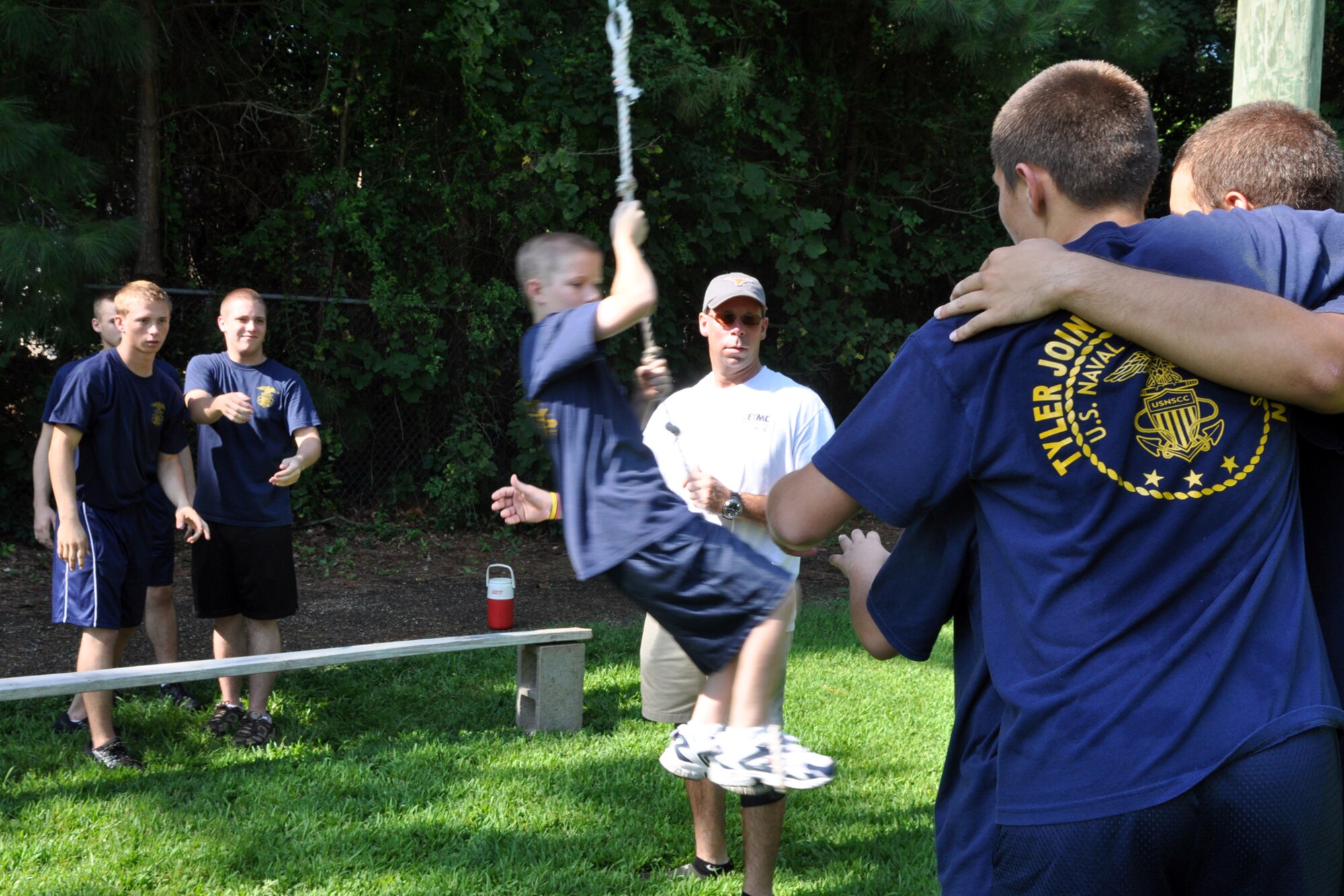 James Whitaker, activities therapy coordinator, East Texas Medical Center/Behavioral Health Center observes cadets from the TYLER JOINT FORCE Battalion of the U.S. Naval Sea Cadets Corps take part in an exercise called “Nitro Crossing” at the Behavioral Health Center in Tyler, Texas, August 15, 2009. The exercise, which involves swinging on a rope across and expanse to their teammates, who are standing on a two foot by two foot platform, is used to enhance the planning process and trust between the cadets. The exercise also required the cadets, at some point, to get a jug of water over the expanse to the teammates without spilling a drop. The exercise, which proved to be very difficult to accomplish, will also benefit those cadets who decide to join the U.S. Military in the future. One of the objectives of the NSCC is to present the advantages and prestige of a military career, and to increase the potential for advancement of those cadets who may wish to join the Navy, Marine Corps, Coast Guard or Merchant Marine. (Courtesy photo)