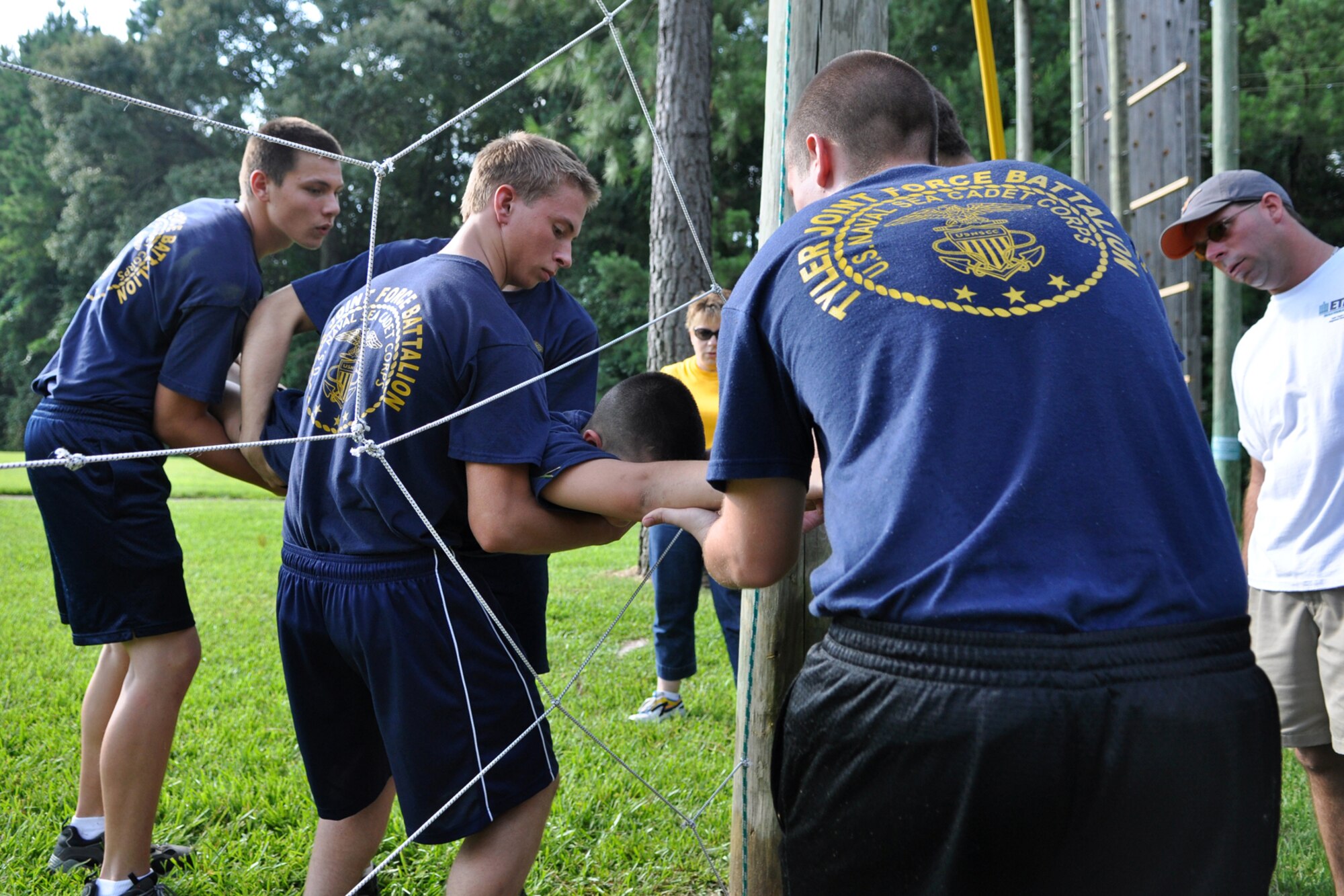 James Whitaker, activities therapy coordinator, East Texas Medical Center/Behavioral Health Center observes cadets from the TYLER JOINT FORCE Battalion of the U.S. Naval Sea Cadets Corps take part in an exercise called “Spider Web” at the Behavioral Health Center in Tyler, Texas, August 15, 2009. The exercise is used to enhance team work and trust between the cadets. The exercise also teaches participants planning techniques and how to be aware of their surroundings. The cadets spent the entire summer day completing exercises which will enable them to work closer with and trust their fellow cadets. This experience will also benefit those cadets who decide to join the U.S. Military in the future. One of the objectives of the NSCC is to develop as sense of pride in our nation, positive qualities of patriotism, courage, self-reliance, confidence, pride in workmanship and seamanship skill, and other attributes which will contribute to development of strong moral character and good citizenship traits. (Courtesy photo)  