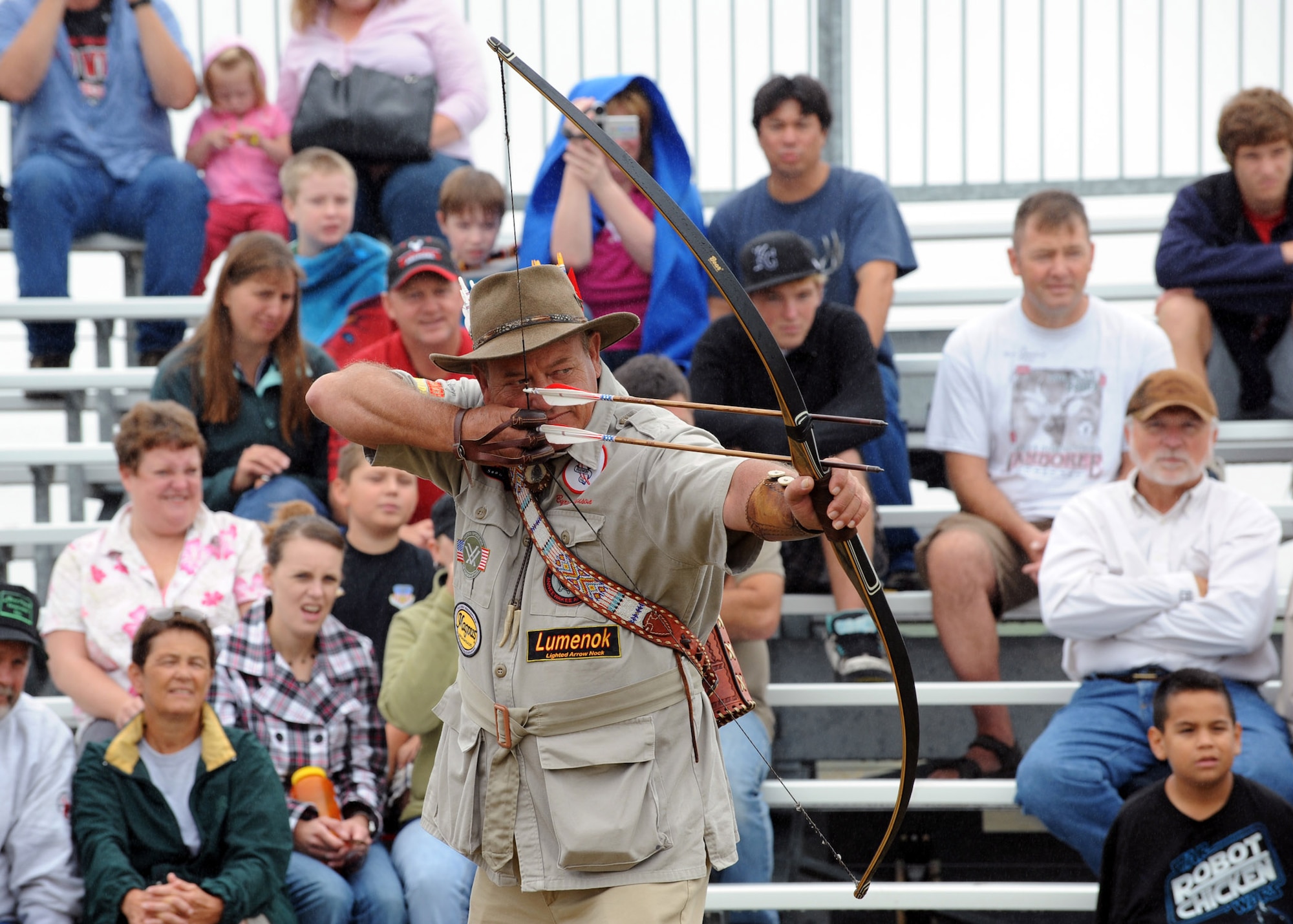 MINOT AIR FORCE BASE, N.D. -- The world’s greatest expedition shooter, Byron Ferguson of Hartselle, Alabama, shoots two separate arrows at two different targets as spectators look on during the grand opening of the new 3-D archery range here, Aug. 15. Ferguson came to Minot to open the 3-D archery range hosted by outdoor recreation, talk about archery safety, and to demonstrate some of his trick shots with his long bow. (U.S.  Air Force photo by Staff Sgt. Keith Ballard)