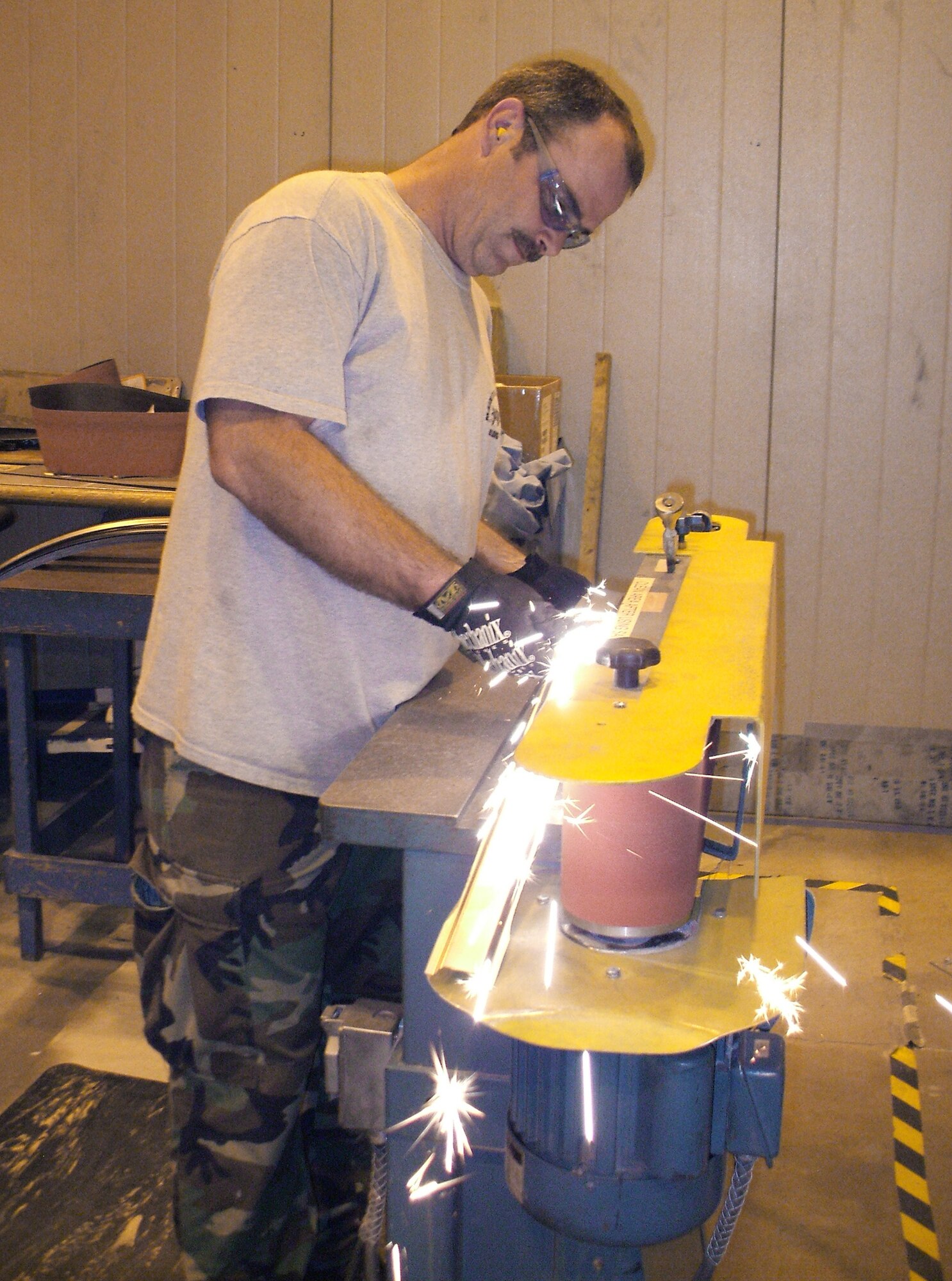 David Stroupe grinds a steel part to the required dimensions for the C-130 Hercules infrared suppression system Aug. 13 at Robins Air Force Base, Ga. Mr. Stroupe is a sheet metal mechanic. (U.S. Air Force photo/Dave Hoffman) 