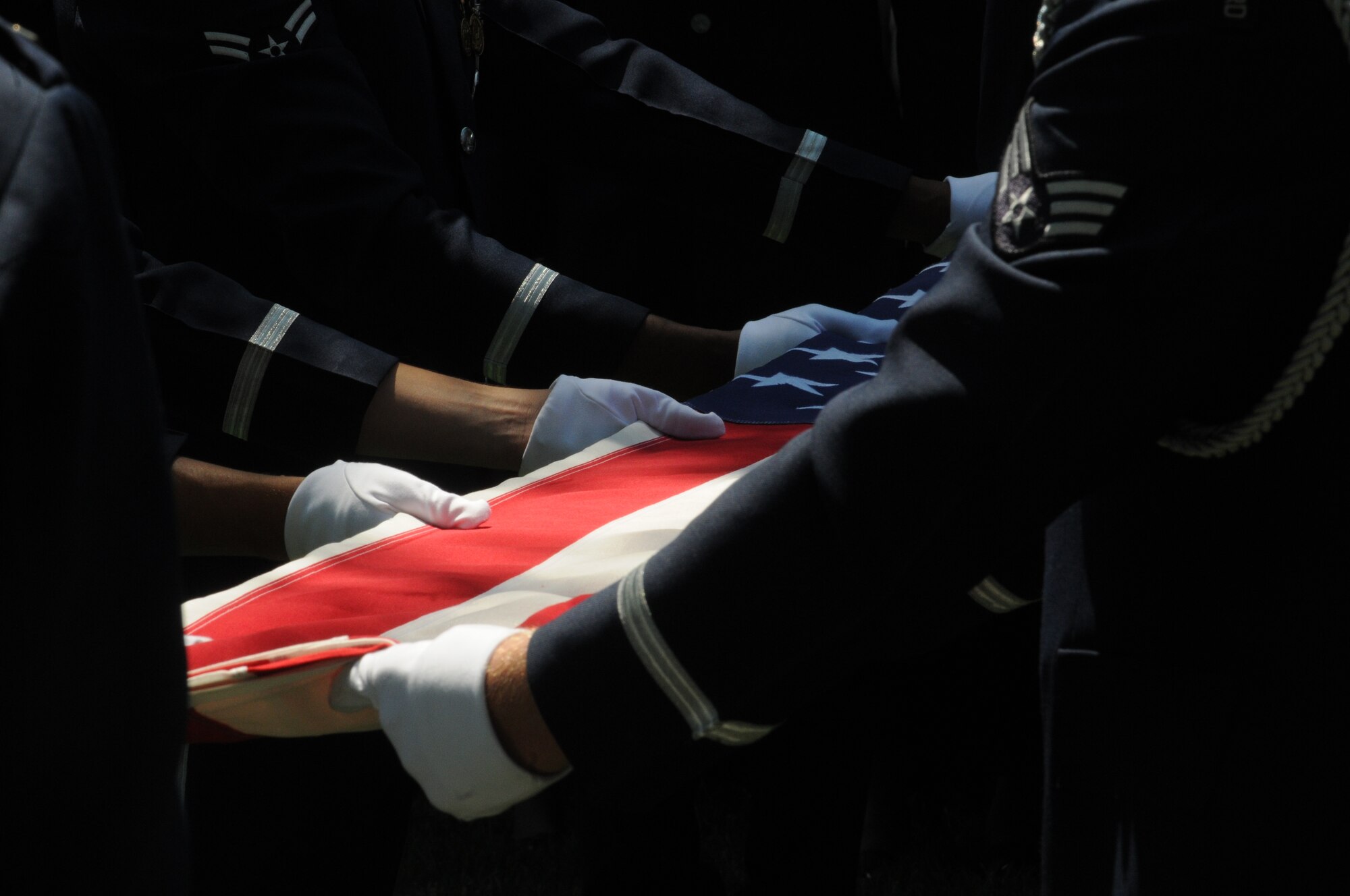 A United States Air Force Honor Guard body bearer team folds the U.S. flag during a full honors funeral ceremony at Arlington National Cemetery. Honor guard body bearers train constantly to maintain the precision they are known for. Their standards of flawlessness are set out of necessity to honor fallen Airmen. (U.S. Air Force photo by Senior Airman Sean Adams)