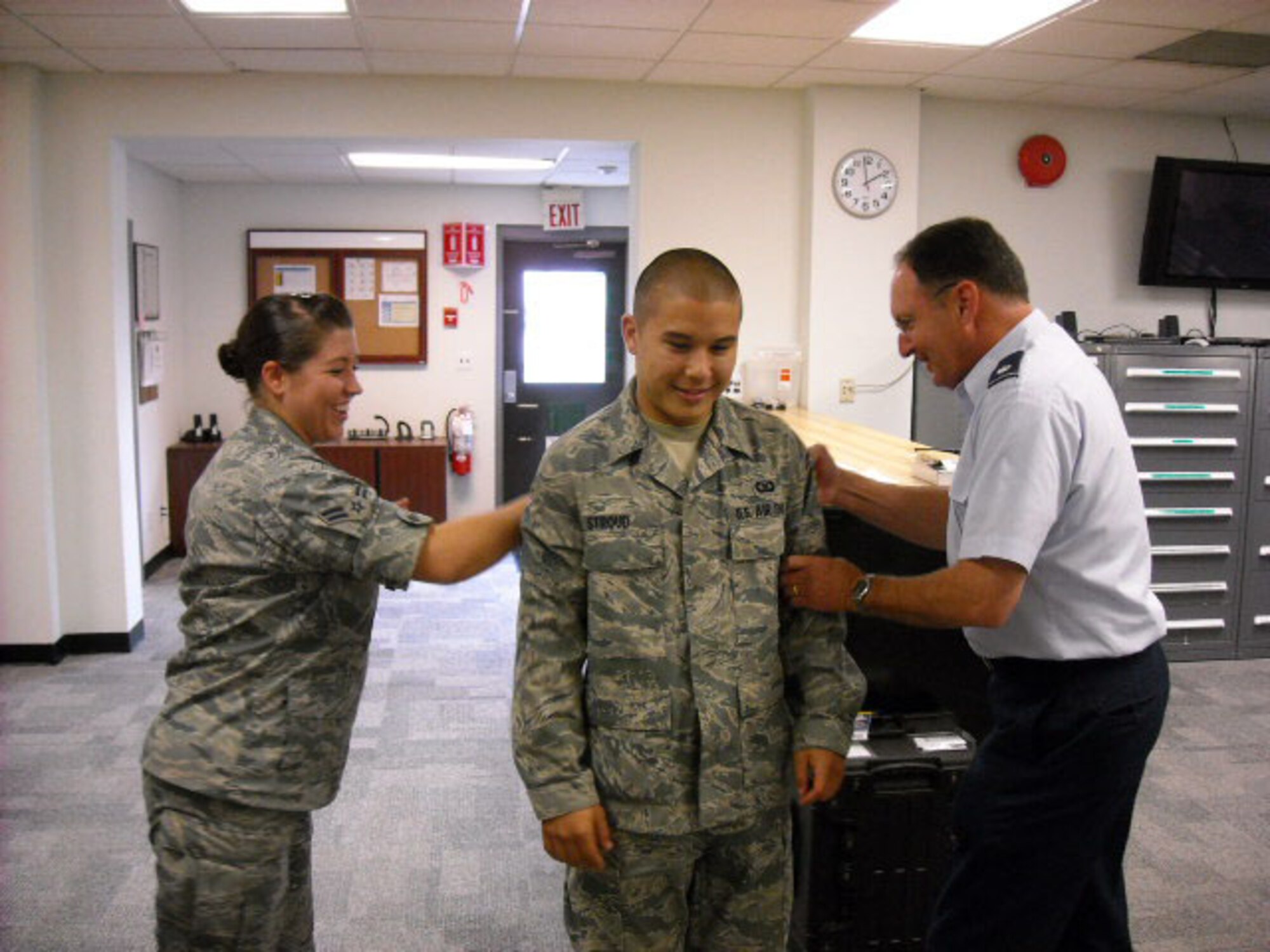 SEYMOUR JOHNSON AIR FORCE BASE, N.C. --   Reservist Jesse Stroud (center) pins on the rank of airman in mid-August.  Airman Stroud works in the 916th Air Refueling Wing Aircrew Flight Equipment shop and was pinned by Lt. Col. Paul Evans (right) and Airman First Class Mallory Burrous.