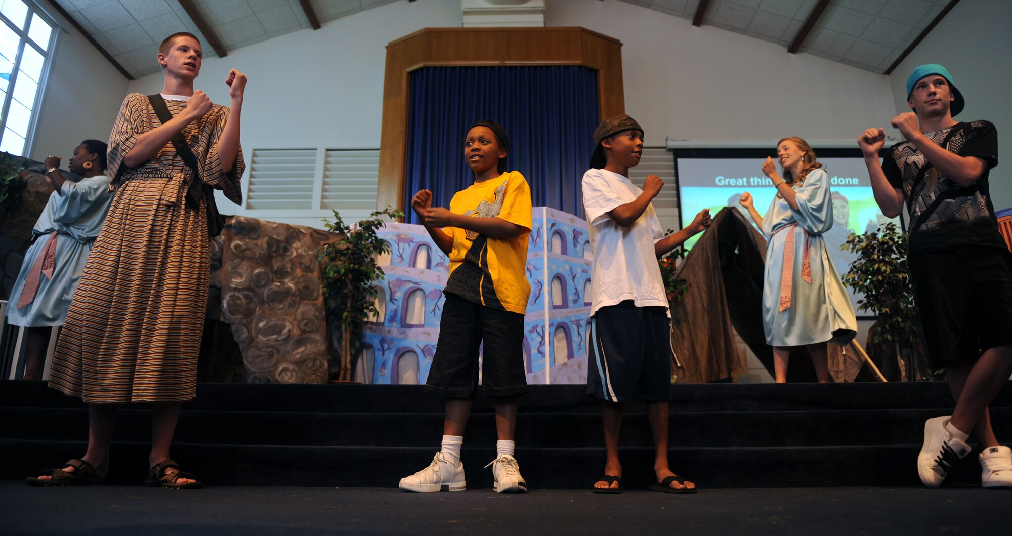 MOUNTAIN HOME AIR FORCE BASE, Idaho - A group of children attending the Vacation Bible School at the chapel dance and sing during praise time Aug. 13. The Liberty Chapel Protestant community hosted the VBS for children ages 4 to 12 from Aug. 10 through 14. Throughout the week, they became part of history as they saw, heard, touched and even tasted what it was like to live in Rome during Bible times. They explored authentic Marketplace shops, visited the Apostle Paul (who’s under house arrest), snuck to the cave where the Underground Church met, took part in games, danced to lively Bible songs, and sampled tasty tidbits as they discovered more about the early church. (U.S. Air Force photo by Airman 1st Class Renishia Richardson)