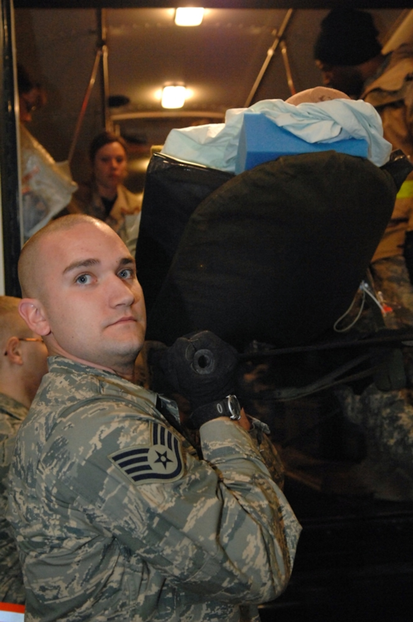 Staff Sgt. Jason Leonard, an aeromedical technician, unloads a Critical Care Air Transport Team, or CCATT, patient from a litter bus during Operation Iraqi Freedom at Balad Air Base, Iraq recently. The CCATT’s mission is to operate an intensive care unit in an aircraft during flight, helping enable America to follow through on its promise to the critically wounded warrior.  The teams are made up of three members, a critical care physician and nurse, and a respiratory therapist, and can care for up to three critically injured, monitored patients, or up to six less severely injured patients, for 72 hours. (U.S. Air Force Photo/Senior Airman Julianne Showalter) 