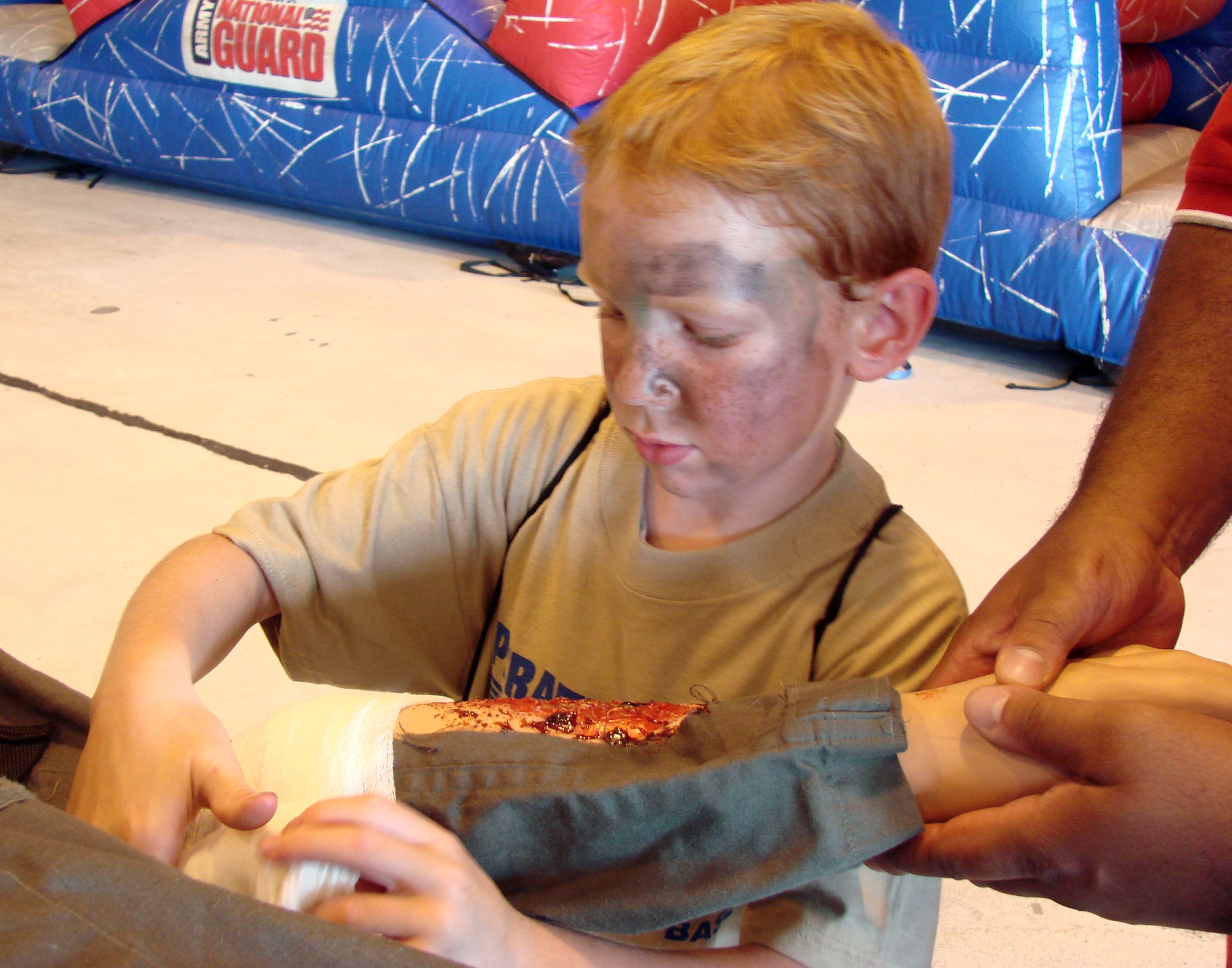 Christian Browne bandages a dummy at the first-aid station at Camp Liberty in Hangar 170, the “deployment” site for the Operation KIDS event, Aug. 6 at Vance AFB, Okla. The event was a hands-on activity for children of military families to learn about their parents’ deployment process. (U.S. Air Force photo/ Danielle Lutes)