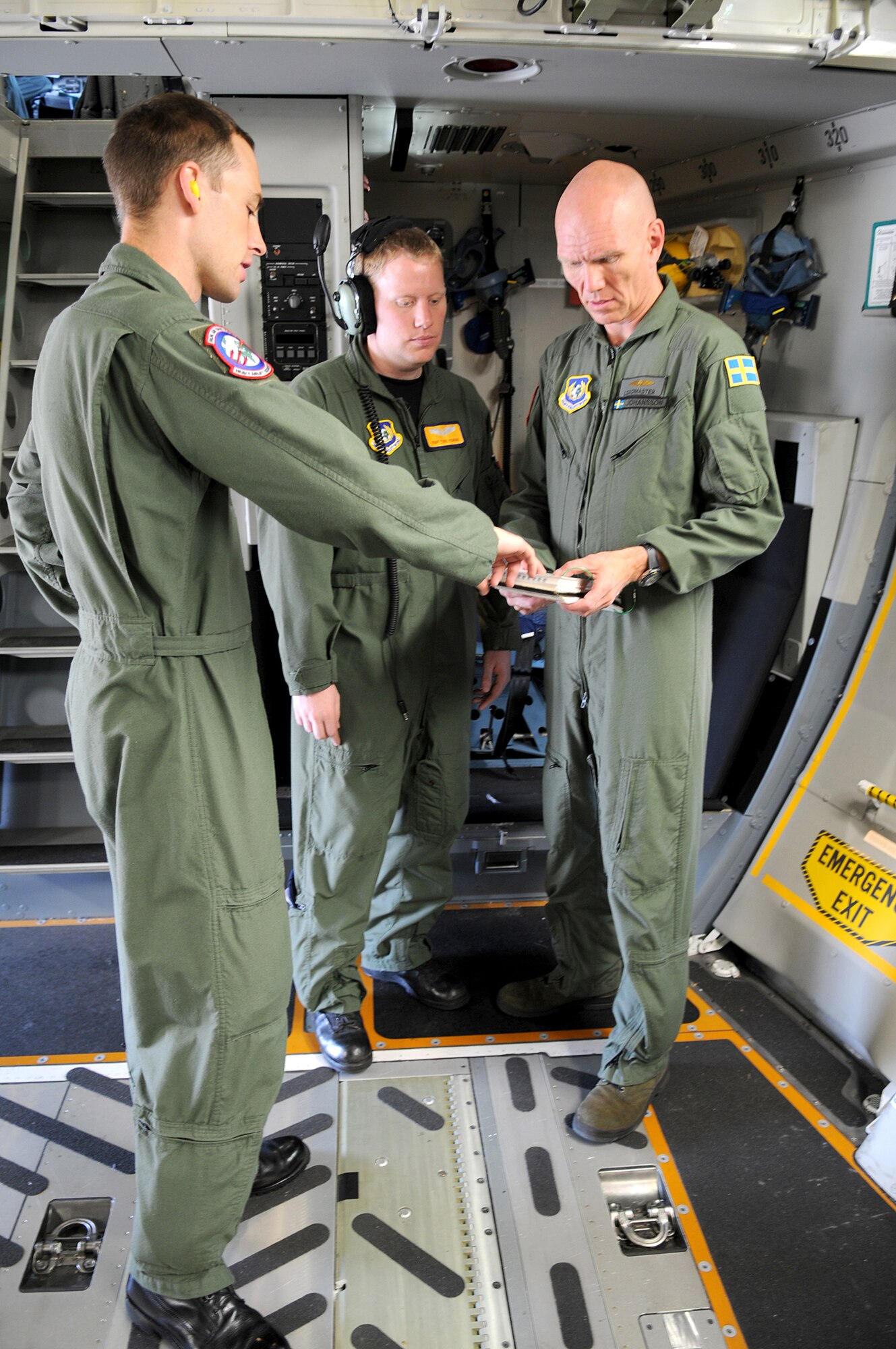 From left to right: U.S. Air Force Tech. Sgt. Chris Copans, Staff Sgt. Todd Perkins and Swedish 1st Lt. Harry Johansson, C-17 loadmasters assigned to the Heavy Airlift Wing Pápa Air Base, Hungary, go over a preflight checklist prior to departing Ramstein Air Base, Germany. The HAW, is comprised of 11 European nations which operate independently of NATO's military command, and was created to help nations meet global reach commitments.  (U.S. Air Force photo by Staff Sgt. Markus M. Maier)