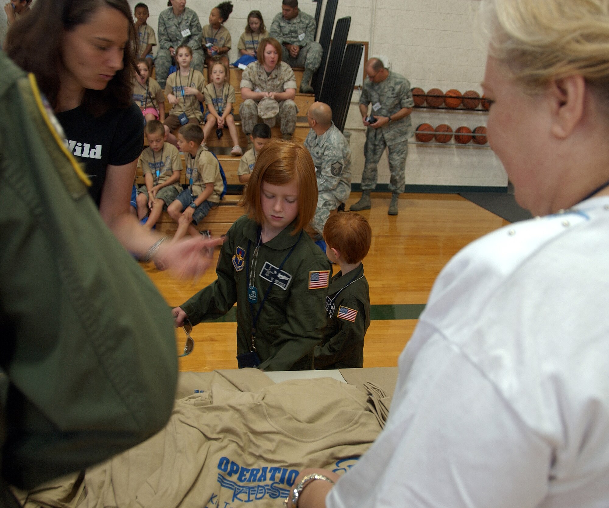 One of the children participating in Operation KIDS, Aug. 6 at Vance AFB, Okla., goes through the processing line to receive her gear for her “deployment” to Camp Liberty in Hangar 170. Operation KIDS was a hands-on event for children of military families to learn about their parents’ deployment process. (U.S. Air Force photo/ 1st Lt. Agneta Murnan)