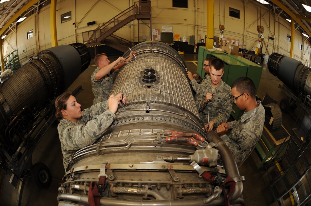 (Left to right) Airman 1st Class Stacie Powers, Jason Pettine, Jon Bettenhausen, Justin Hildreth and Khayan Martinez, 28th Maintenance Squadron aerospace propulsion apprentices, remove bolts as a team from a fan duct on a B-1B Lancer engine here, August 13.  The Airmen remove the fan duct to access blades in need of repair. (U.S. Air Force photo/Airman 1st Class Anthony Sanchelli)