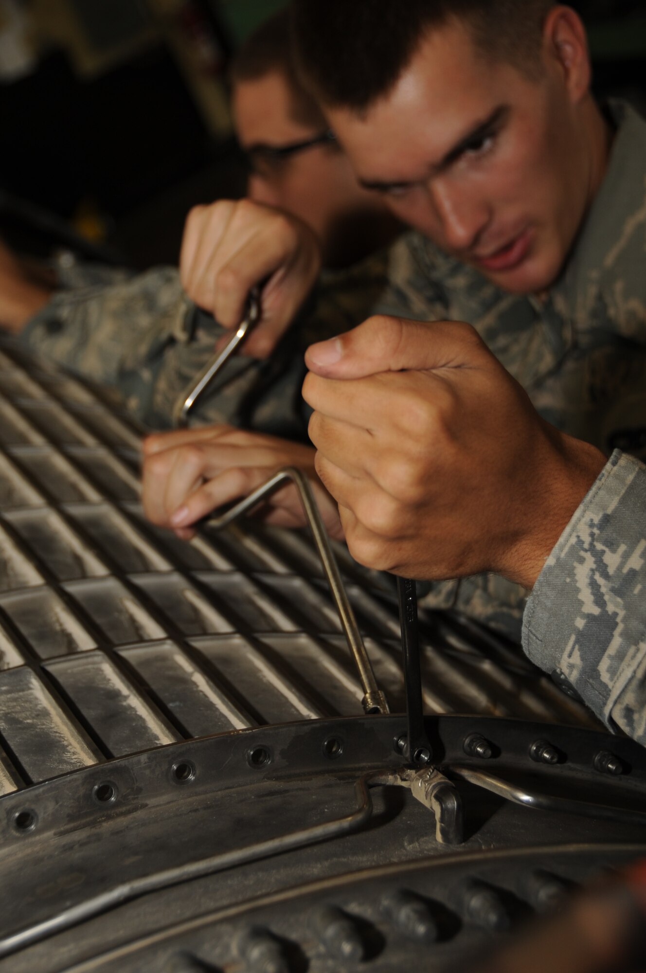 Airman 1st Class Justin Hildreth, 28th Maintenance Squadron aerospace propulsion apprentice, removes bolts from a fan duct on a B-1B Lancer engine here, August 13.  Airman Hildreth removes the fan duct to access blades in need of repair. (U.S. Air Force photo/Airman 1st Class Anthony Sanchelli)
