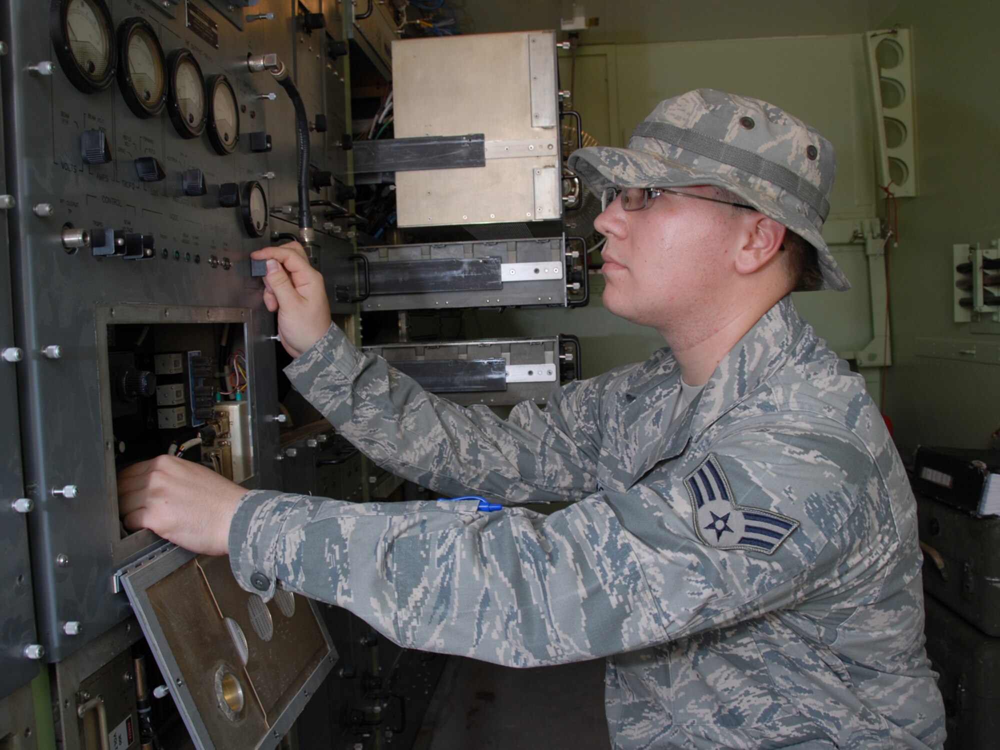 Senior Airman Justin Brassell, 379th Expeditionary Communications Squadron satellite wideband technician, adjusts the power output on a high-power signal amplifier for the AN/TRC-170 satellite dish, here, Aug. 18. Airman Brassell is a native of Lorton, Va., and is deployed from Tinker Air Force Base, Okla. in support of Operations Iraqi and Enduring Freedom.  (U.S. Air Force Photo/Tech. Sgt. Jason W. Edwards)