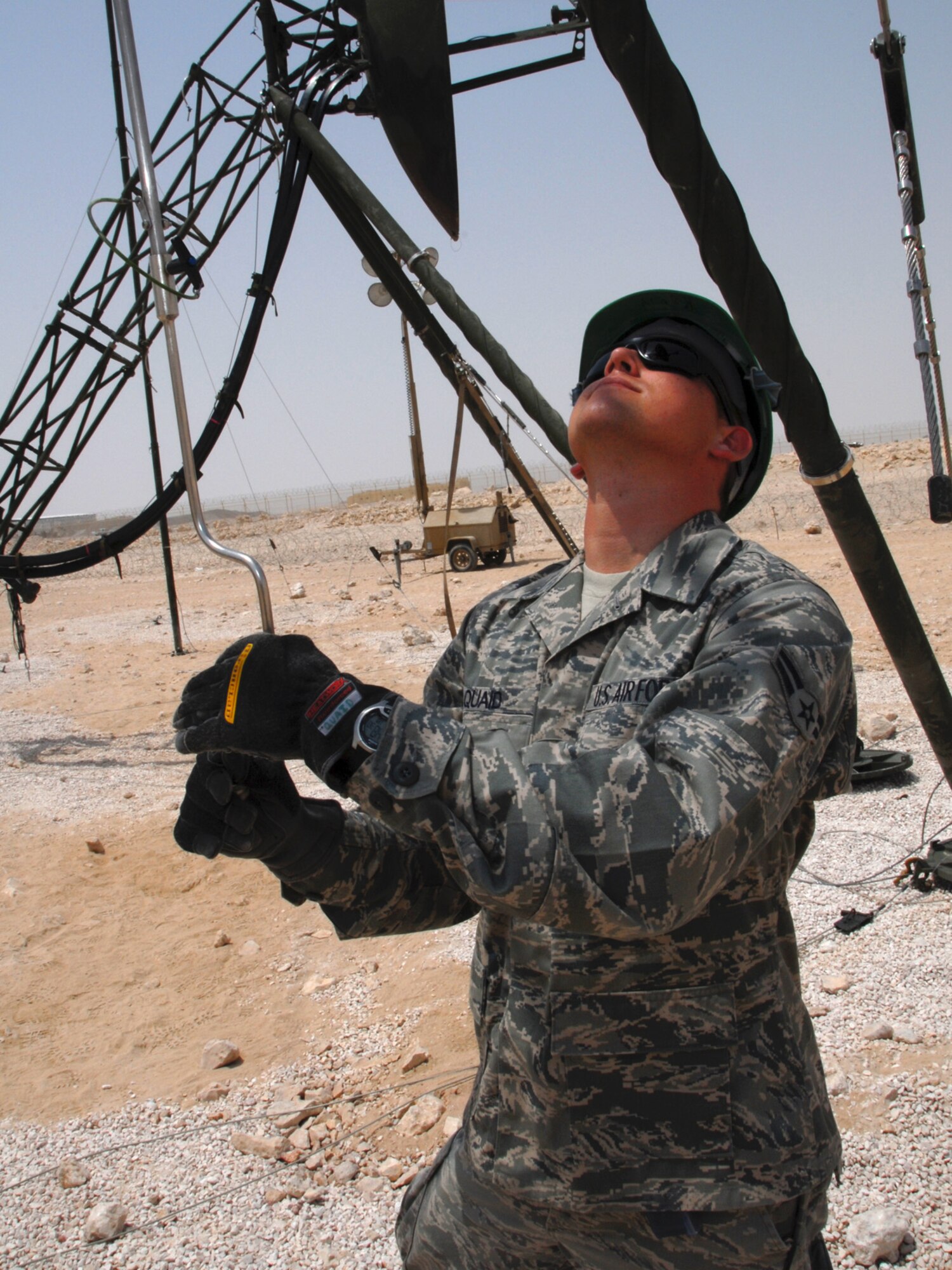 Airman 1st Class Angus Quaid, 379th Expeditionary Communications Squadron satellite wideband and telemetry apprentice, adjusts azimuth and elevation for the AN/TRC-170 satellite dish, here, Aug. 18. Airman Quaid is a native of Oklahoma City, Okla., and is deployed from Tinker Air Force Base, Okla. in support of Operations Iraqi and Enduring Freedom.  (U.S. Air Force Photo/Tech. Sgt. Jason W. Edwards)