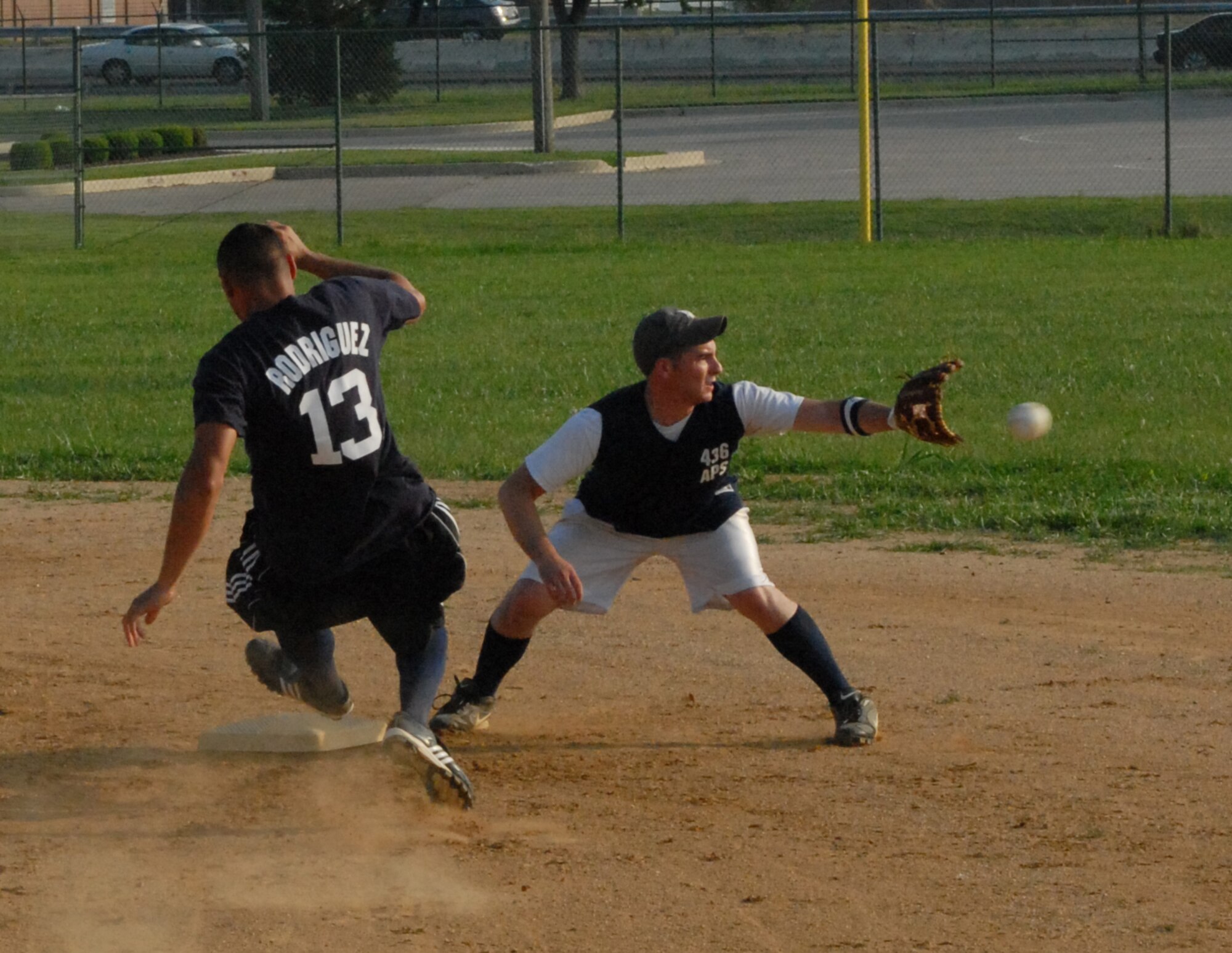 Pedro Pena, 436th Medical Group, slides into second as the 436th Aerial Port Squadron second baseman reaches for the ball.