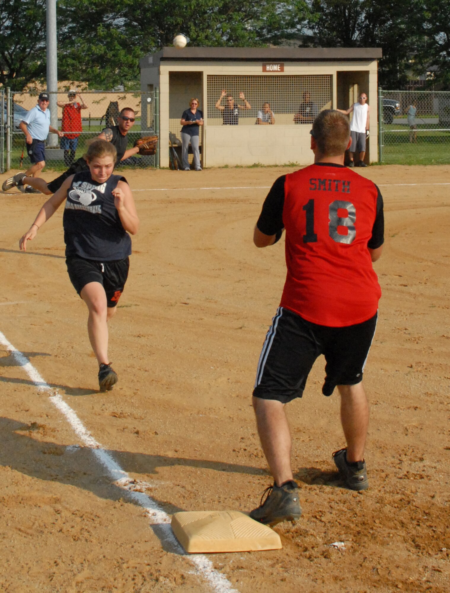 Cassandra Saphore, 436th Medical Group, races for first base as the 436th Aerial Port Squadron pitcher throws the ball to first.