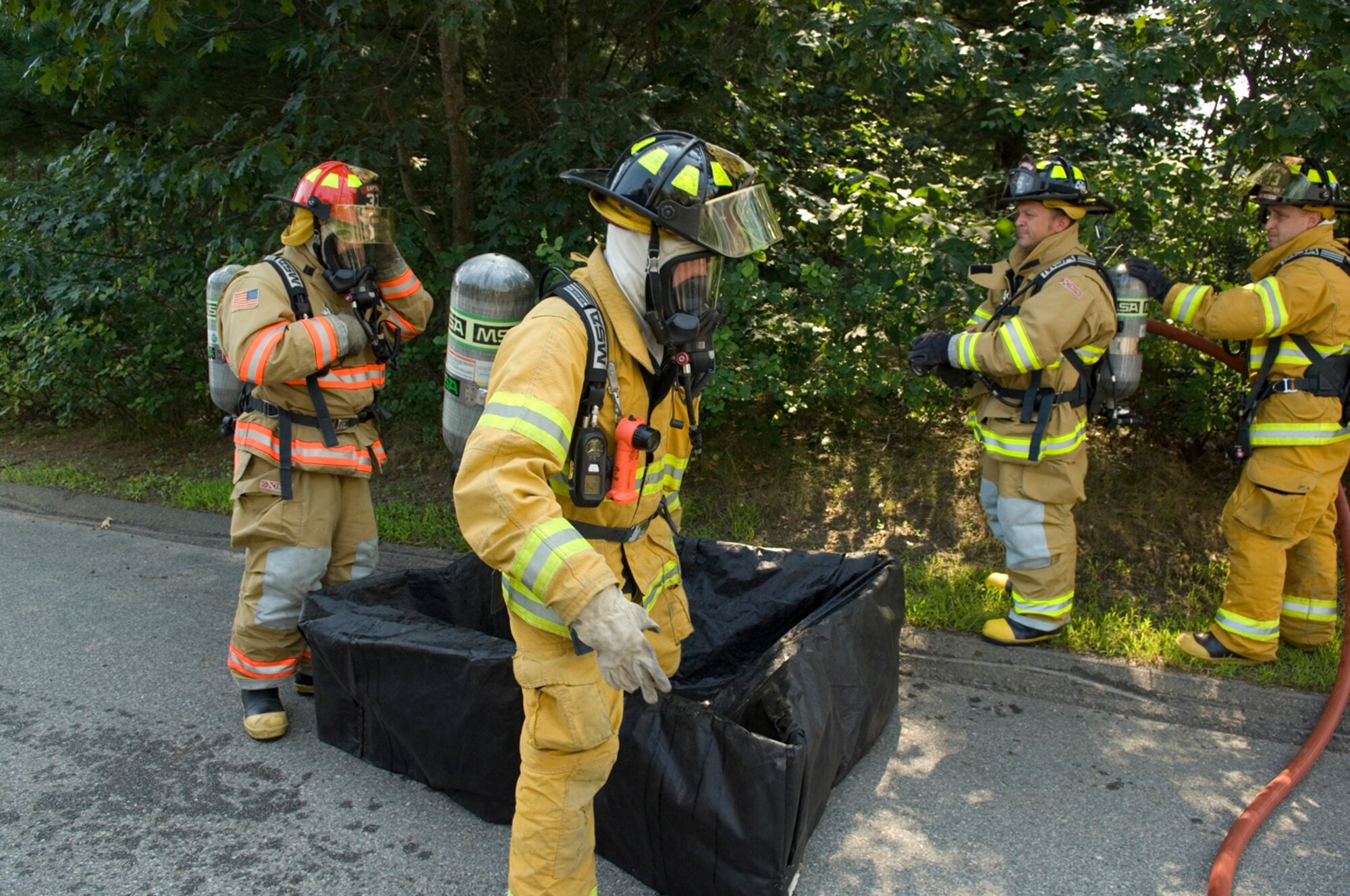 HANSCOM AIR FORCE BASE, Mass. – Hanscom firemen practice decontamination procedures after responding to a simulated hazardous material leak during an emergency management exercise on Aug. 17. Hanscom is undergoing a week-long Base Readiness Exercise that includes emergency management components, Wartime Materiel Support and deployment readiness. (U.S. Air Force photo by Rick Berry)
