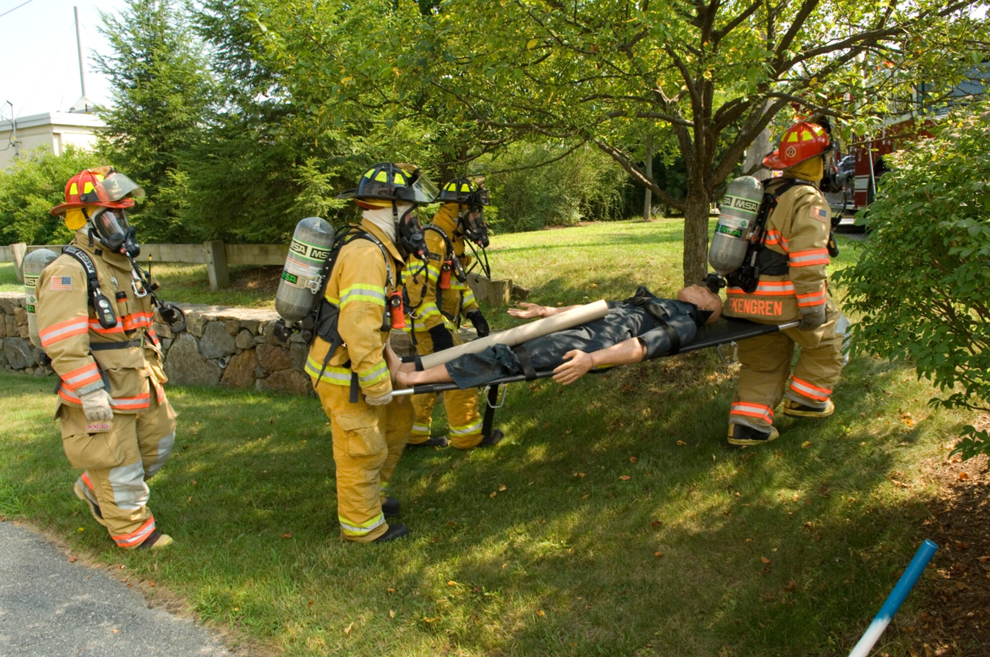 HANSCOM AIR FORCE BASE, Mass. – Members of the Hanscom Fire Department carry a simulated victim of a hazardous material leak during an emergency management exercise on Aug. 17. Hanscom is undergoing a week-long Base Readiness Exercise that includes emergency management components, Wartime Materiel Support and deployment readiness. (U.S. Air Force photo by Rick Berry)