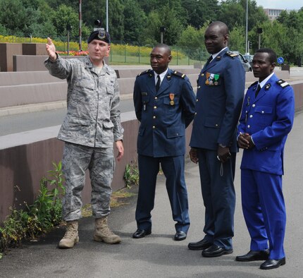 Capt. David Geiger, far left, outlines base entrance security procedures at Ramstein Air Base for a delegation of officers from Burkina Faso. They are, from left, Lt. Dabir? Dapr? Paul, Maj. Souleymane Ouedraogo, and Capt. Hubert Yameoga. The group was the first-ever military exchange from the West African nation to visit Ramstein AB. (USAF photo by Tech. Sgt. Alec Lloyd)