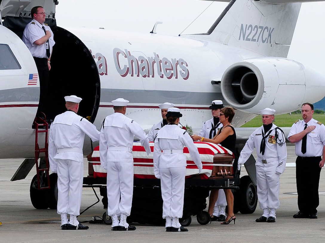 The widow of Capt.Michael Scott Speicher, Joanne Speicher Harris, places flowers on Speicher's coffin on Naval Air Station Jacksonville in Jacksonville, Fla., Aug. 13, 2009. Speicher was killed when his F/A-18 Hornet was shot down over Anbar province, Iraq, on Jan. 17, 1991, the first day of Desert Storm's offensive operations.