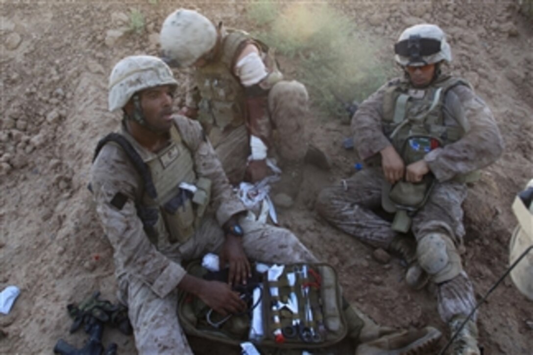 U.S. Navy Petty Officer 2nd Class Lamonte Hammond and Petty Officer 3rd Class Simon Trujillo with Bravo Company, 1st Battalion, 5th Marine Regiment treat a Marine who was wounded during a firefight in the Nawa district of Helmand province, Afghanistan, on Aug. 14, 2009.  Navy corpsmen are first responders to wounded Marines on the battlefield.  The battalion is deployed with Regimental Combat Team 3 to conduct counter insurgency operations in partnership with Afghan National Security Forces in southern Afghanistan.  