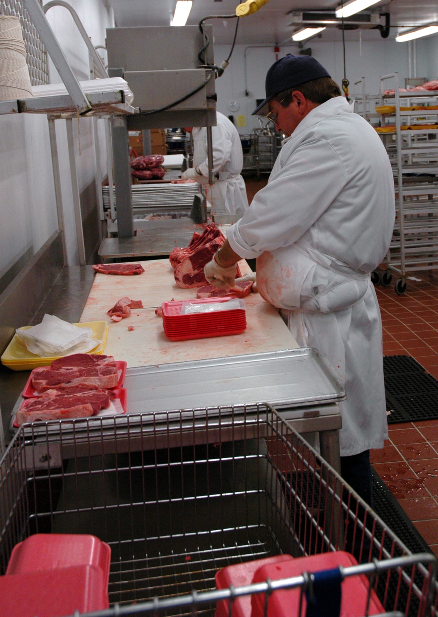 Kevin Larsen, a meat cutter at the Malmstrom commissary, prepares porterhouse steaks for packaging Aug. 18. (U.S. Air Force photo/Valerie Mullett)