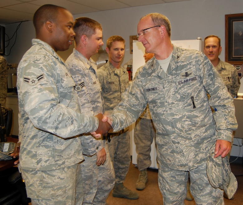 Col. Michael Fortney, 341st Missile Wing commander, gives Airman 1st Class Kevin Love, 341st Missille Maintenance Squadron missile handling team technician, a congratulatory hand shake Aug. 18 in  building 1844 following the insertion of the final Minuteman III booster replaced under the Propulsion Replacement Program at Launch Facility Echo-08. (U.S. Air Force photo/Staff Sgt. Eydie Sakura)