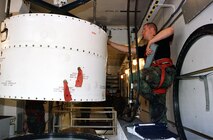 From inside a payload transporter van during the first booster replacement at Malmstrom April 16, 2001, Airman 1st Class  Roger Ridley, 341st Maintenance Squadron, lowers a missile guidance set onto the booster in launch facility Hotel-02 below. (U.S. Air Force photo/John Turner)