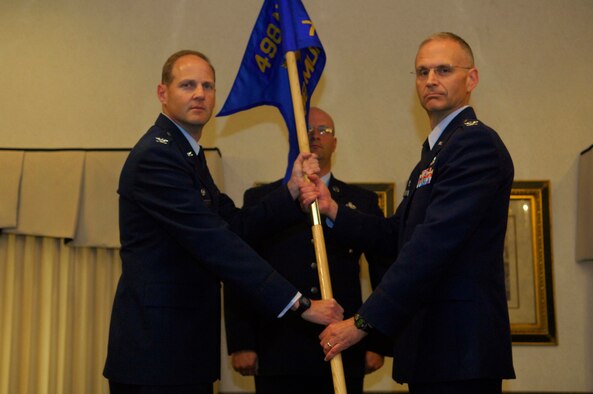 MINOT AIR FORCE BASE, N.D. -- Presiding Officer Col. Richard M. Stuckey, 498th Nuclear Systems Wing Commander, passes the ceremonial flag to Col. David Milner Jr., 798th Munitions Maintenance Group Commander, traditionally signifying the assumption of command over the new 798th Munitions Maintenance Group here, Aug. 18. The 798th MUMG standup is an important step toward establishing support for Air Force Global Strike Command, which is the lead major command for Air Force nuclear operations. (U.S.  Air Force photo by Airman 1st Class Jesse Lopez)