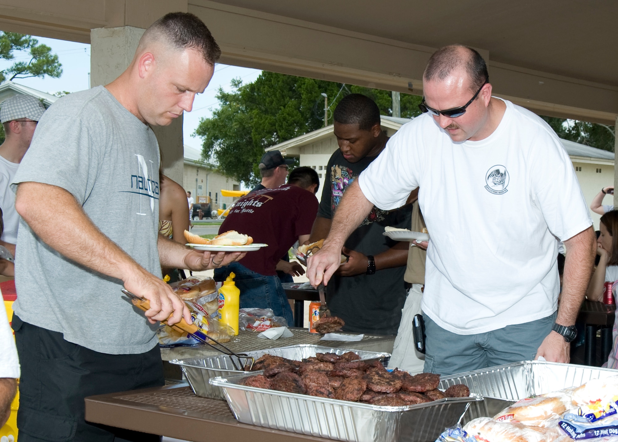 Members of the 53rd Wing dig in to the food provided at the wing’s annual picnic at Eglin Air Force Base, Aug. 14.  The morning was filled with sports events followed by lunch and more games at Eglin’s Post’l Point.  (U.S. Air Force photo/Debbie Haussermann.)