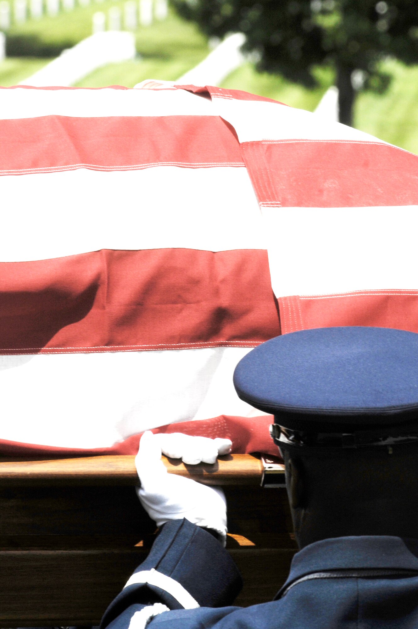 A United States Air Force Honor Guard body bearer lifts a casket to honor a fallen Airman during a full-honors funeral ceremony at Arlington National Cemetery. Honor Guard body bearers train constantly to maintain the precision they are known for. Their standards of flawlessness are set out of necessity to honor fallen Airmen. (U.S. Air Force photo/Senior Airman Alexandre Montes)