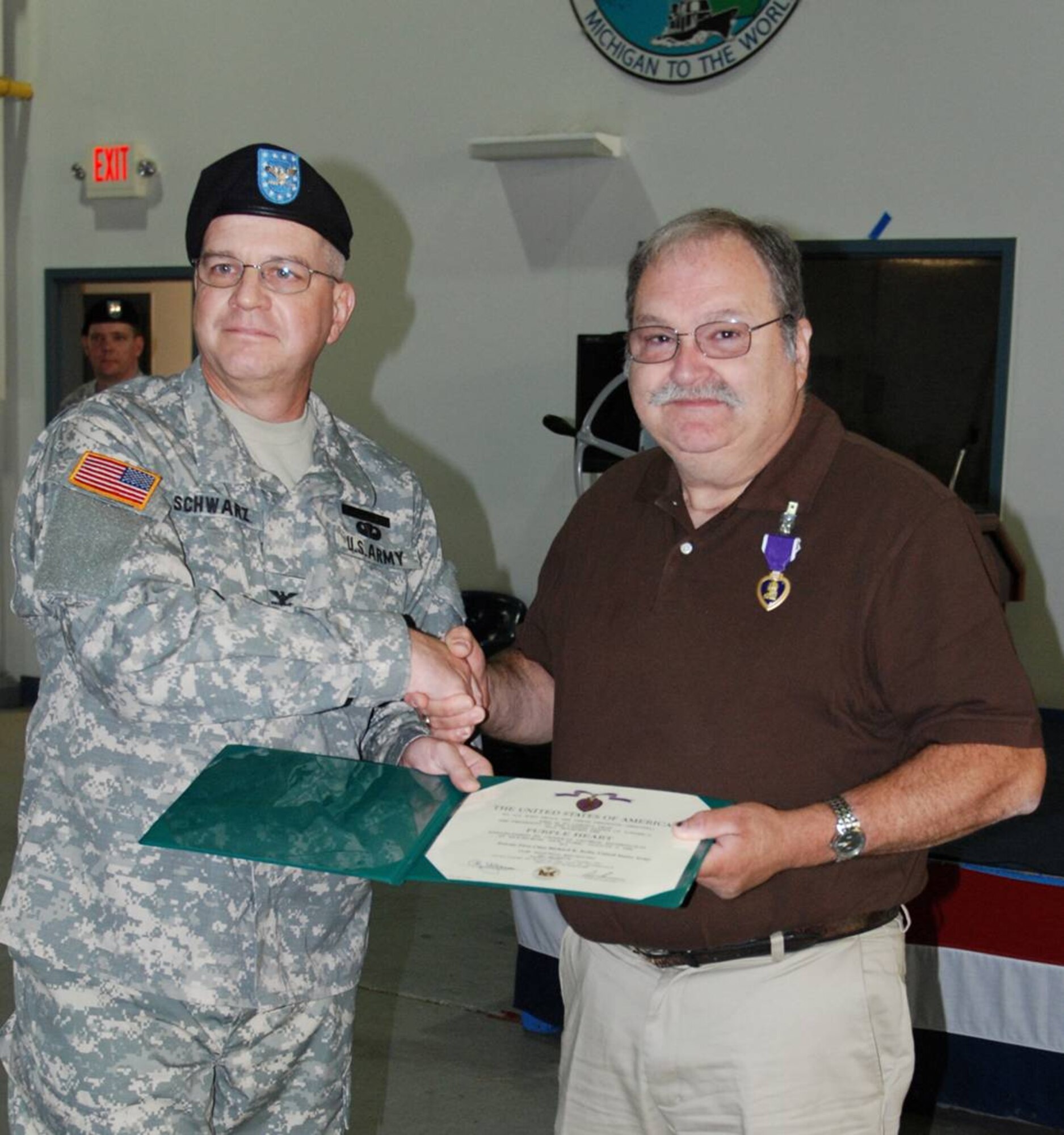 JAC JRISE Detroit Director of Operations, Army Col. Frederick Schwarz presents the  Purple Heart to Mr. Richard Kelts.  Kelts was wounded in Vietnam when his armored personnel carrier hit a mine.  Capt. David A. Kerr of the JRISE (on left behind Col. Schwarz)  took the initiative to ensure that his neighbor received the award in a military ceremony on July 25th after he learned that Kelts received the award unceremoniously in the mail.  (Photo courtesy of Oakland Press, Pontiac, Michigan)