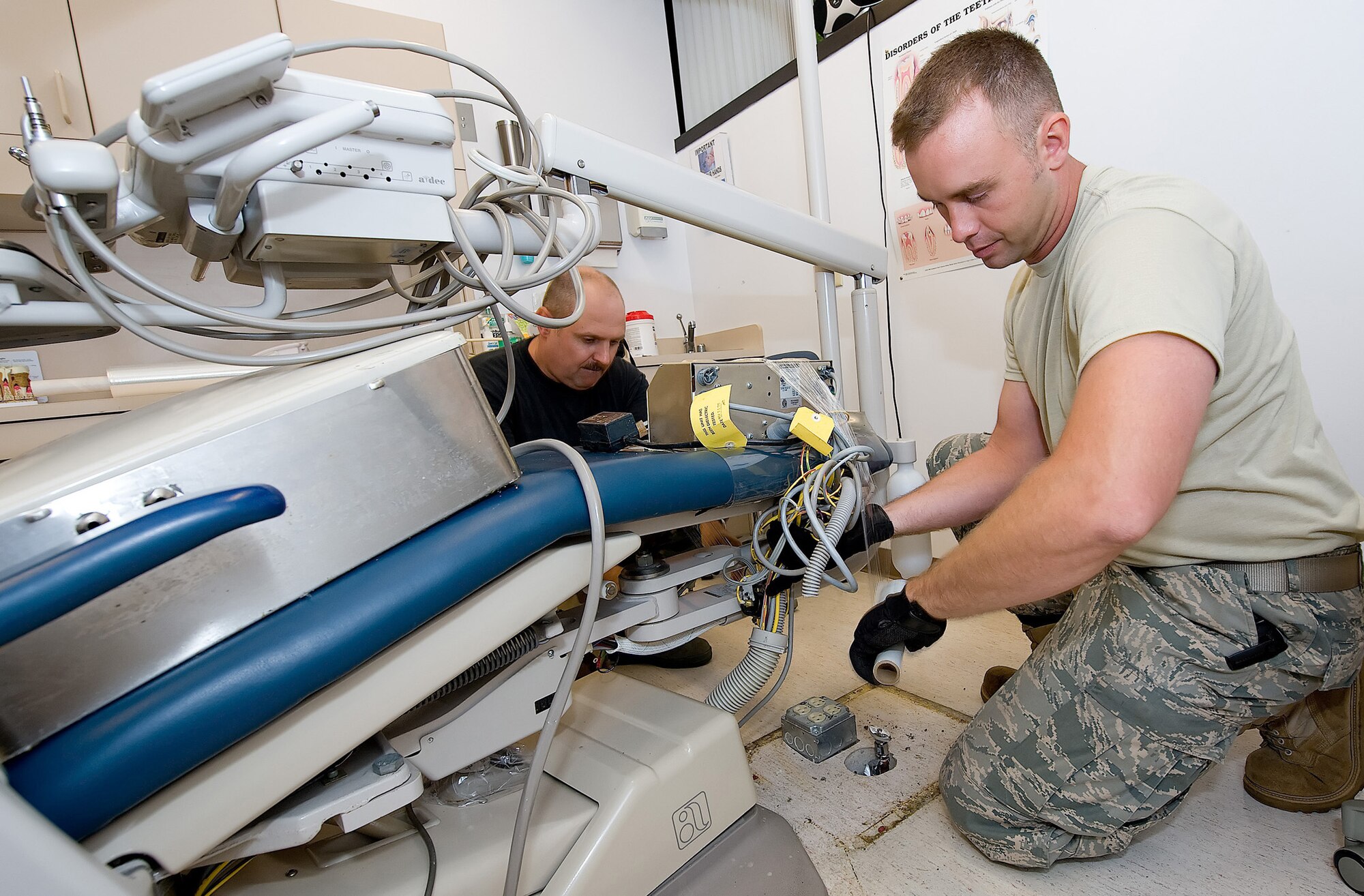 (Left to right) Tech. Sgt. Raymond Worl, 436th Dental Squadron NCO in-charge of the dental laboratory, and Tech. Sgt. Roy Anderson, 436th Medical Support Squadron NCO in-charge medical maintenance, remove dental chairs from the dental clinic Aug. 13. (U.S. Air Force photo/ Jason Minto)