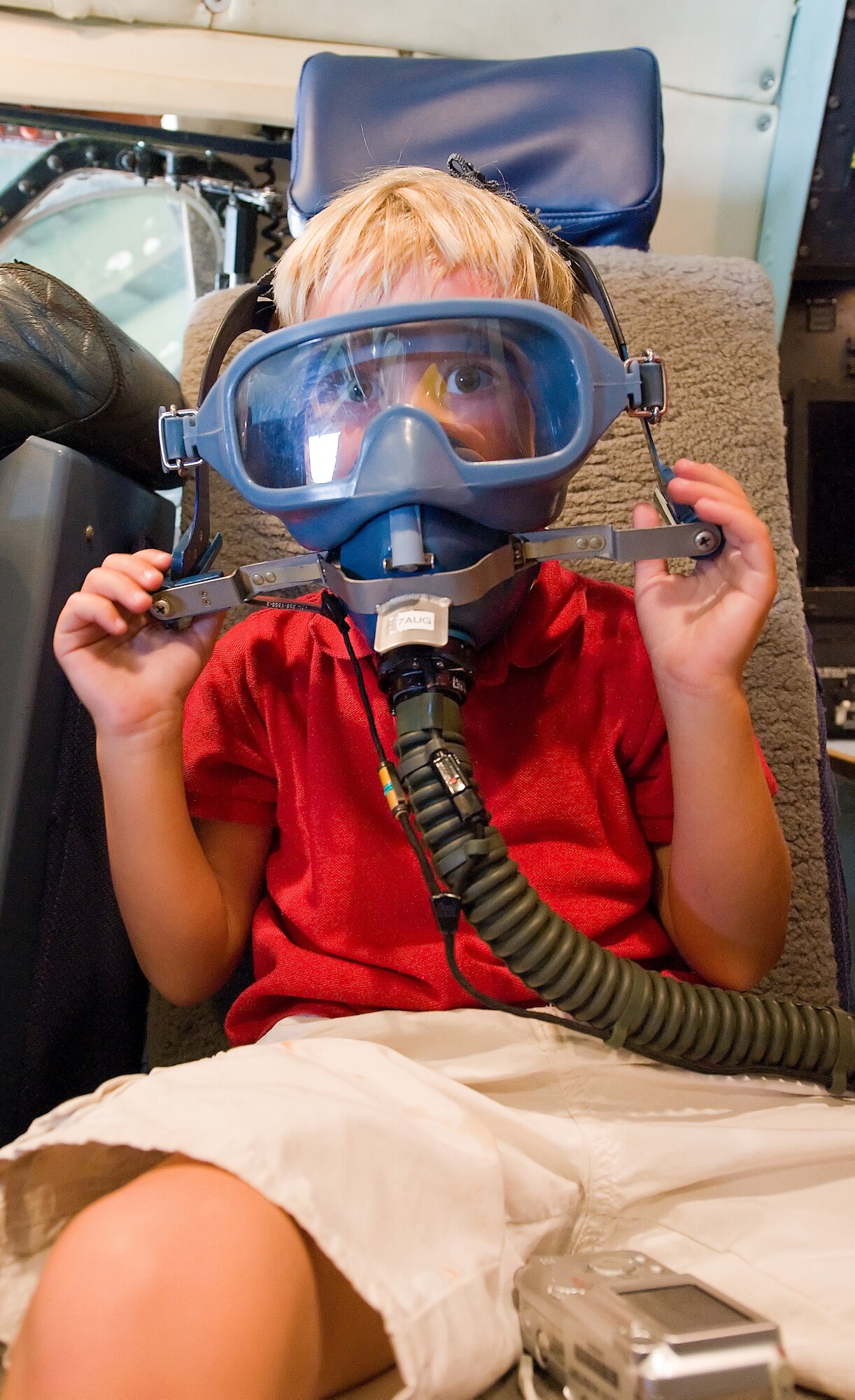 Lex Johnson tries on an oxygen mask during a tour of a C-5 Galaxy aircraft Aug. 3.  Johnson was part of a tour for relatives of former Staff Sgt. Julio Alonso. The Dover Airman Leadership School is named after Sergeant Alonso.  (U.S. Air Force photo/Tom Randle)
