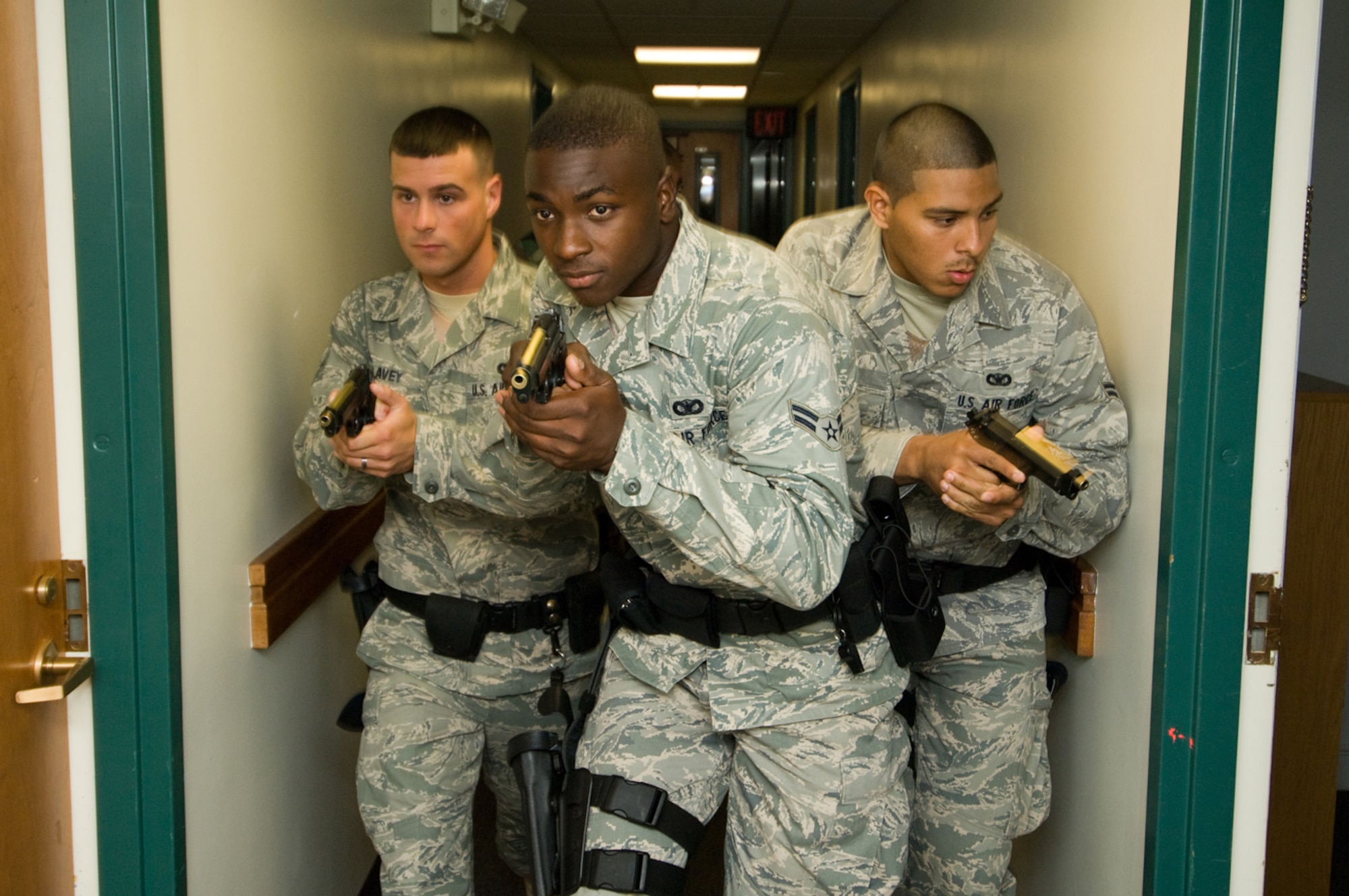 HANSCOM AIR FORCE BASE, Mass. - (From Left) Airman 1st Class Jeffrey Lavey, Airman 1st Class Nicholas Taylor, and Airman 1st Class Abraham Medina, with Staff Sgt. Christopher Darrow (not pictured, in rear), all with the 66th Security Forces Squadron, move along the corridors of the dormitories on Aug. 6 during a training session with the Massachusetts State Police Special Tactical Operations Team where they learned how to diffuse an active-shooter scenario. (U.S. Air Force photo by Rick Berry)