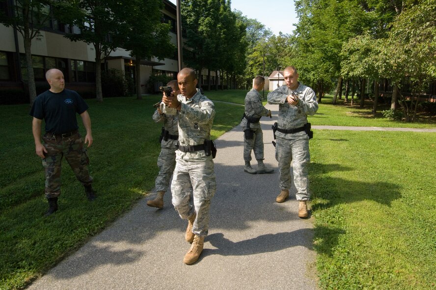 HANSCOM AIR FORCE BASE, Mass. - (From right) Senior Airman John Reed, Airman 1st Class Edwin Torres, Airman 1st Class Ronald Ashley and Senior Airman Mark Cayer, all of the 66th Security Forces Squadron, train with the Massachusetts State Police Special Tactical Operations Team Aug. 6 to learn methods for neutralizing an active shooter, which is a person with a weapon threatening themselves and others within a confined space. Trooper Jim Carmichael (far left), one of the trainers with the Massachusetts State Police Special Tactical Operations Team, educates the Airmen on moving into and within the threat space using a diamond formation, where each member of the four-man team monitors a quarter of the 360-degree view around them. This is the second time the state trooper STOP Team conducted the training for the 66 SFS, which followed the same format as in March, combining classroom sessions with field exercises using Simunition rounds. (Air Force photo by Rick Berry) 