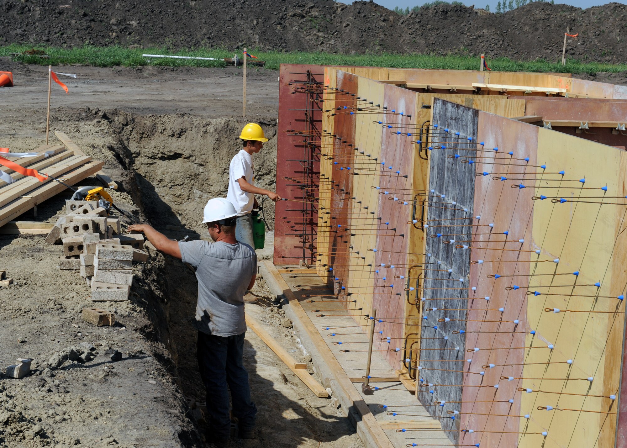 MINOT AIR FORCE BASE, N.D. -- Members of Telehey Construction Company spray form release agent on a temporary wooden wall in preparation of adding reinforcing bars designed to add strength to a concrete foundation at a new radar site here, Aug. 11. The digital airport surveillance radar, or DASR-11 program, is expected to be completed in April of 2010. The DASR-11 will be able to track, discern between military and civilian aircraft in and around the city of Minot.  (U.S. Air Force photo by Staff Sgt. Keith Ballard)