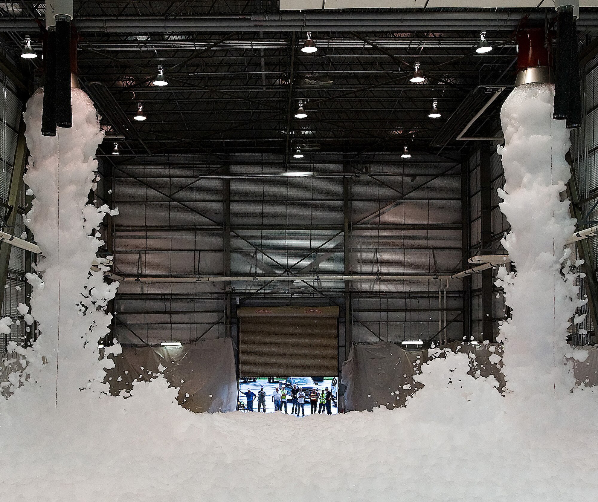 Foam erupts from a newly-installed fire safety system during a preliminary test Aug. 12 at Hanger 945. The mixture in the system uses only 2 percent foam and 98 percent water, allowing it to run longer and produce more foam to put out hanger fires. (U.S. Air Force photo/Tom Randle)
