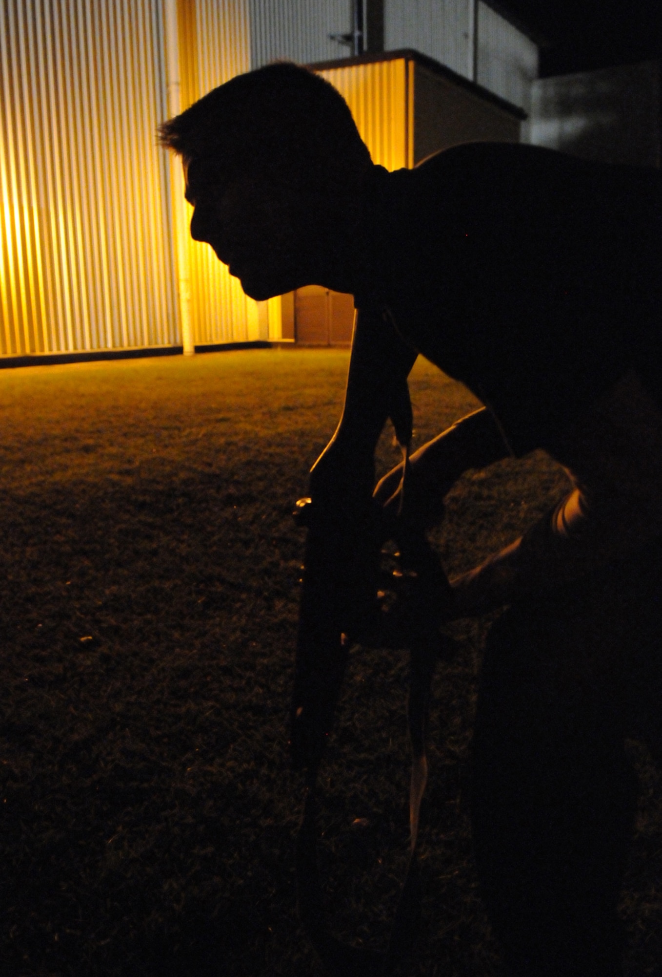 RAF MILDENHALL, England – Airman 1st Class Daniel Bratt, 100th Security Forces Squadron, sneaks toward the Base X perimeter just outside the reach of a security light.  Opposition Forces members spent several nights testing the abilities of the 100th Security Forces Squadron to defend a deployed installation.   (U.S. Air Force photo by Staff Sgt. Austin M. May)