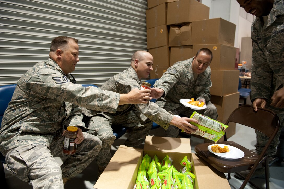 Left to right, Tech. Sgt. Tracy Locke, Staff Sgt. Brian Franks, Tech. Sgt. Tim Vigenser, and Senior Airman Adam Carter, 340th Expeditionary Air Refueling Squadron, take a break and enjoy chips and salsa, July 29, in Southwest Asia. The snacks, and other assorted care package items, where part of a community care package drive for deployed personnel serving in the Arizona National Guard. The Airmen are deployed from the 161st Air Refueling Wing in support of Operations Iraqi and Enduring Freedom. (U.S. Air Force Photo by Staff Sgt. Robert Barney/Released)